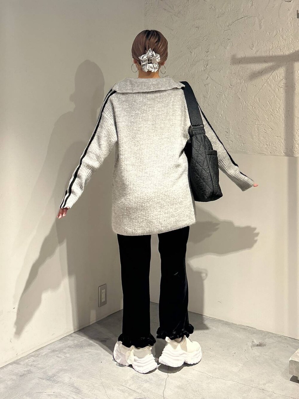 ブラック系のその他パンツ、ブラック系のショルダーバッグ、ホワイト系のスニーカーを着用したレディースの秋コーディネートの3枚目の写真