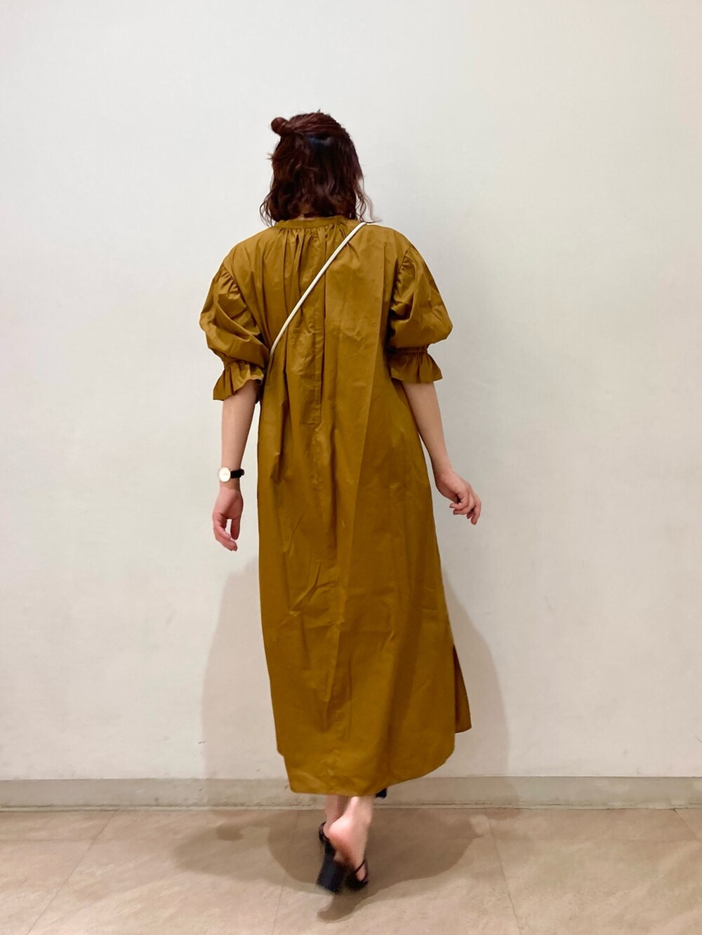 ブラウン系のワンピース、ホワイト系のショルダーバッグ、ブラック系のサンダルを着用したレディースの春コーディネートの2枚目の写真