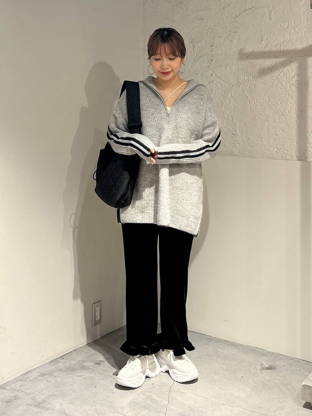 ブラック系のその他パンツ、ブラック系のショルダーバッグ、ホワイト系のスニーカーを着用したレディースの秋コーディネートの2枚目の写真