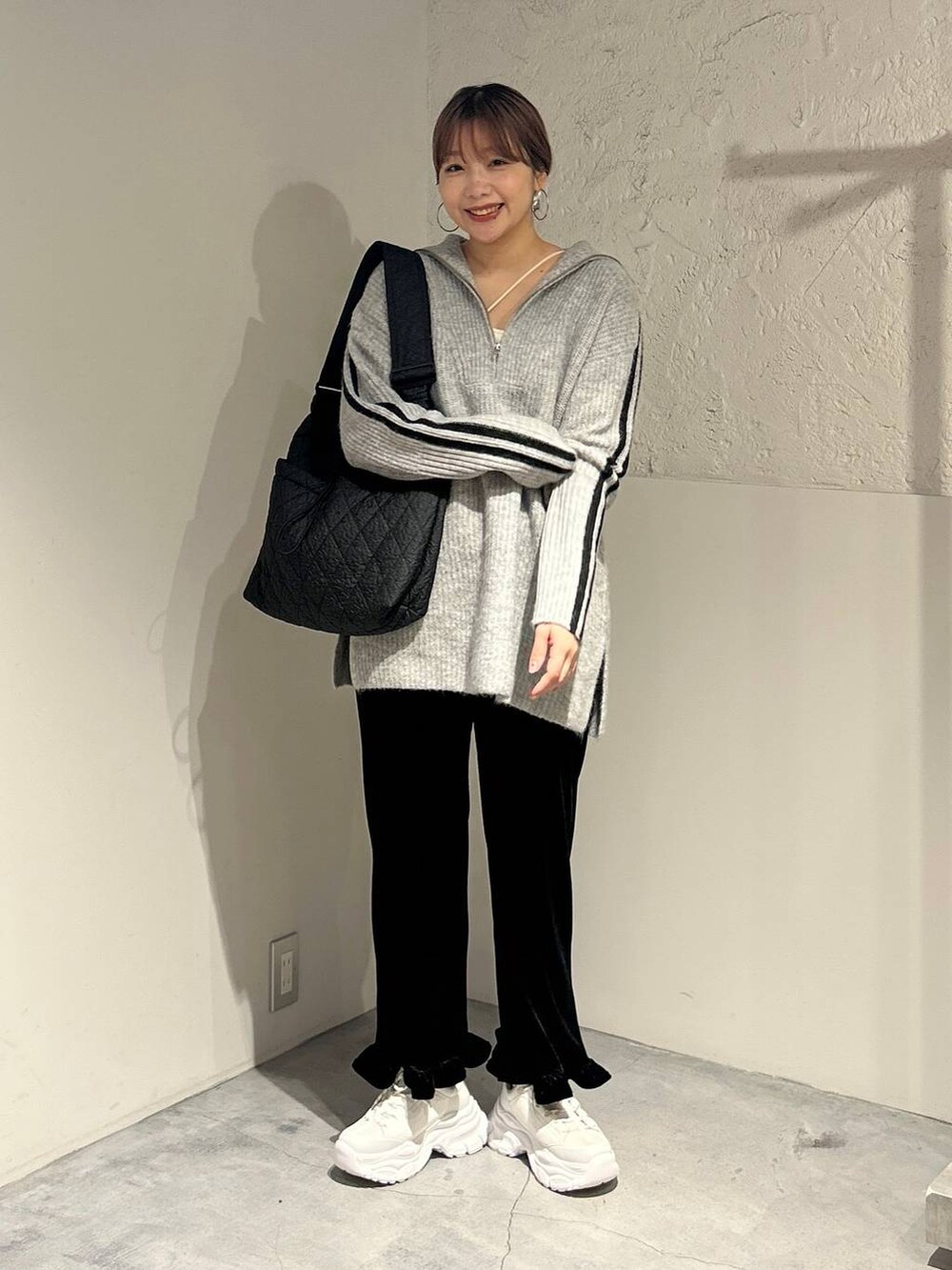 ブラック系のその他パンツ、ブラック系のショルダーバッグ、ホワイト系のスニーカーを着用したレディースの秋コーディネートの4枚目の写真