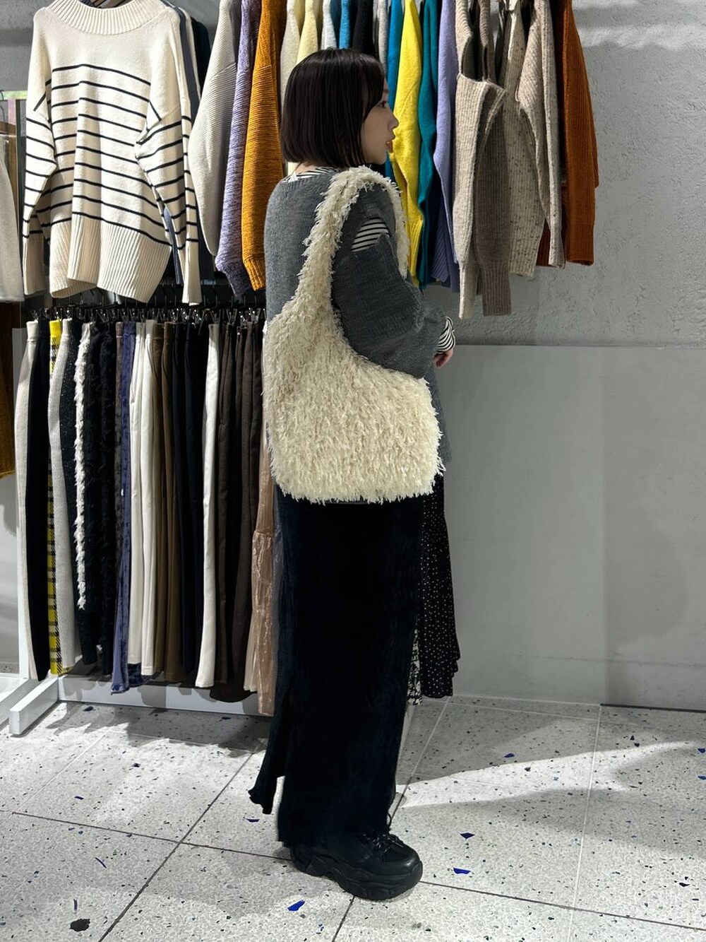 ホワイト系のTシャツ/カットソー、ブラック系のスカート、ブラック系のスニーカーを着用したレディースの冬コーディネートの2枚目の写真