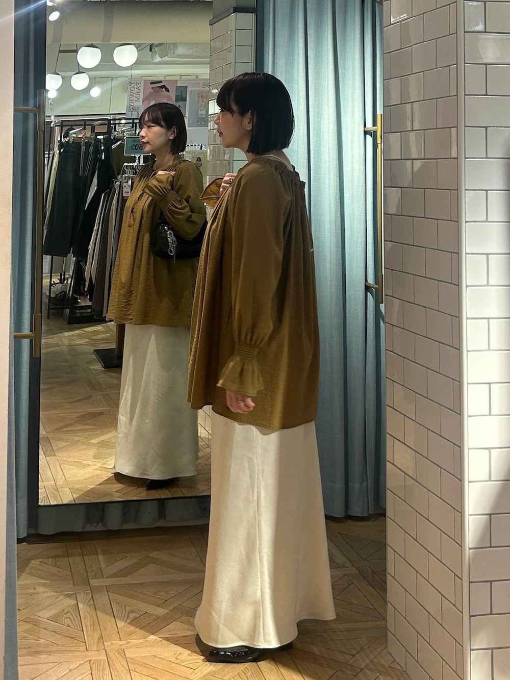 ブラック系のトートバッグ、ブラック系のパンプス、ベージュ系のシャツ/ブラウスを着用したレディースの春コーディネートの3枚目の写真