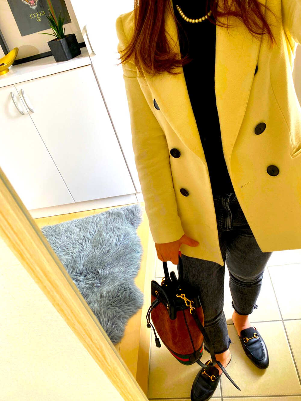 ブラック系のデニムパンツ、ブラック系のニット/セーター、ブラック系のバッグを着用したレディースの冬コーディネートの2枚目の写真