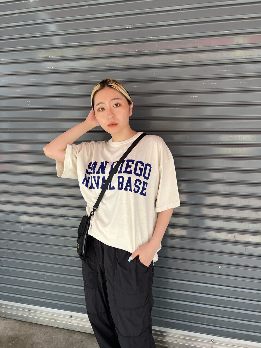 ホワイト系のTシャツ/カットソー、ブラック系のショルダーバッグ、ブラック系のその他パンツを着用したレディースの夏コーディネートの2枚目の写真