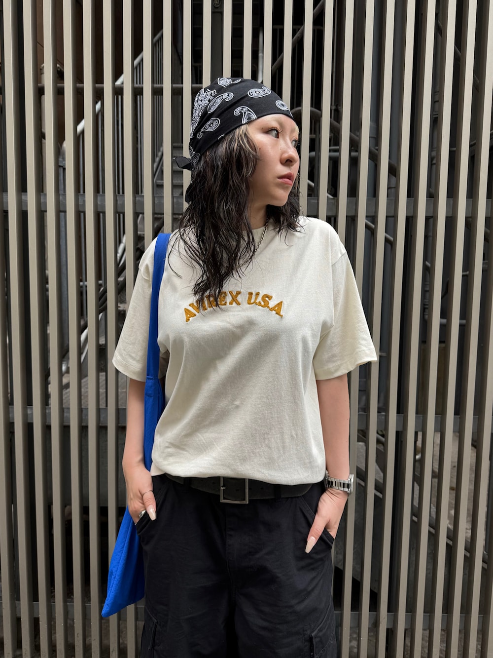 ホワイト系のTシャツ/カットソー、ブラック系のカーゴパンツ、ブラック系のベルトを着用したレディースの夏コーディネートの4枚目の写真