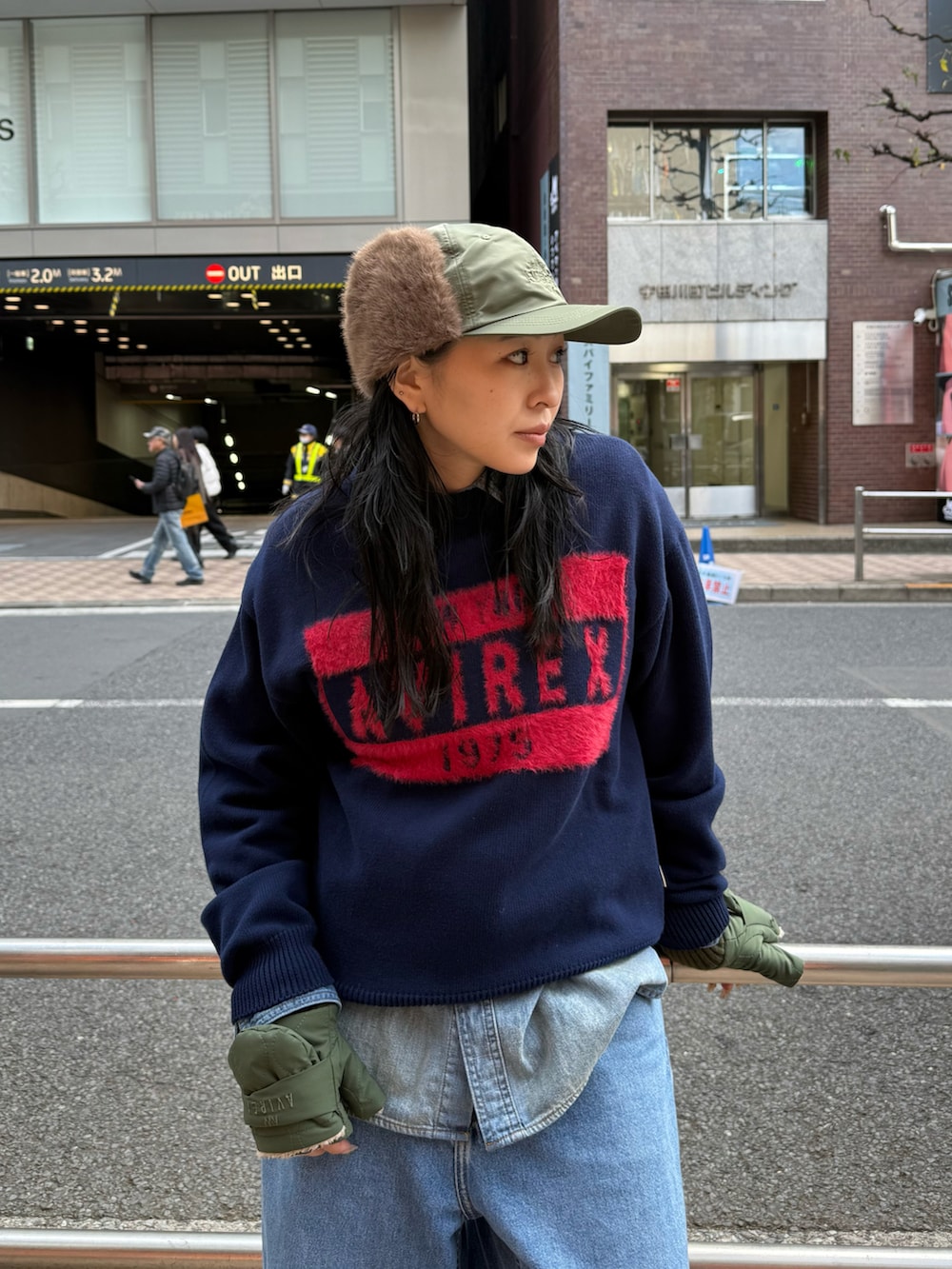 ブルー系のニット/セーター、グリーン系のキャップ、グリーン系の手袋を着用したレディースの秋コーディネートの4枚目の写真