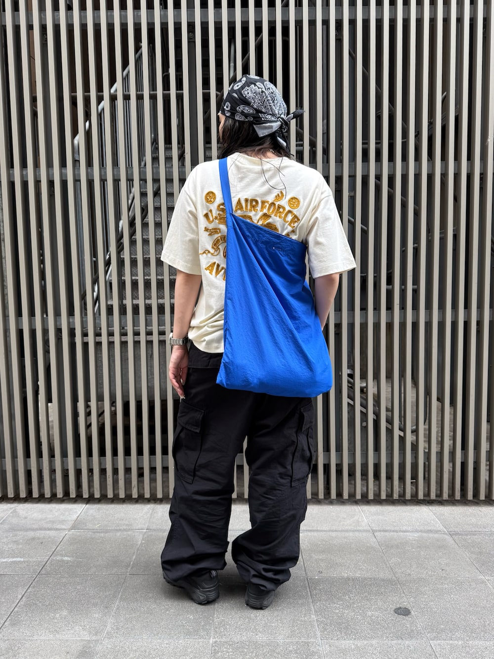 ホワイト系のTシャツ/カットソー、ブラック系のカーゴパンツ、ブラック系のベルトを着用したレディースの夏コーディネートの3枚目の写真
