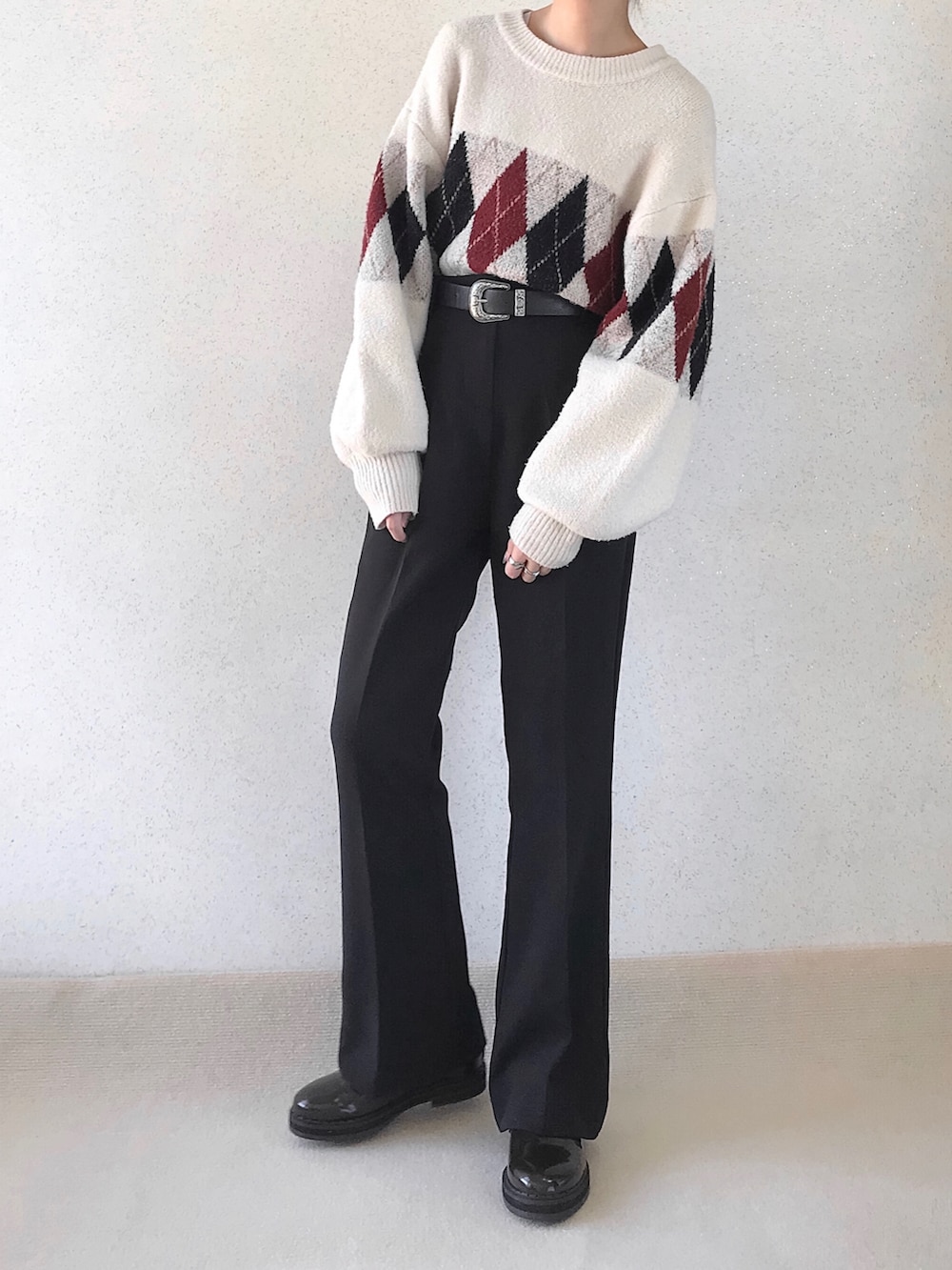 ホワイト系のニット/セーター、ブラック系のスラックス、ブラウン系のドレスシューズを着用したレディースの秋コーディネートの2枚目の写真