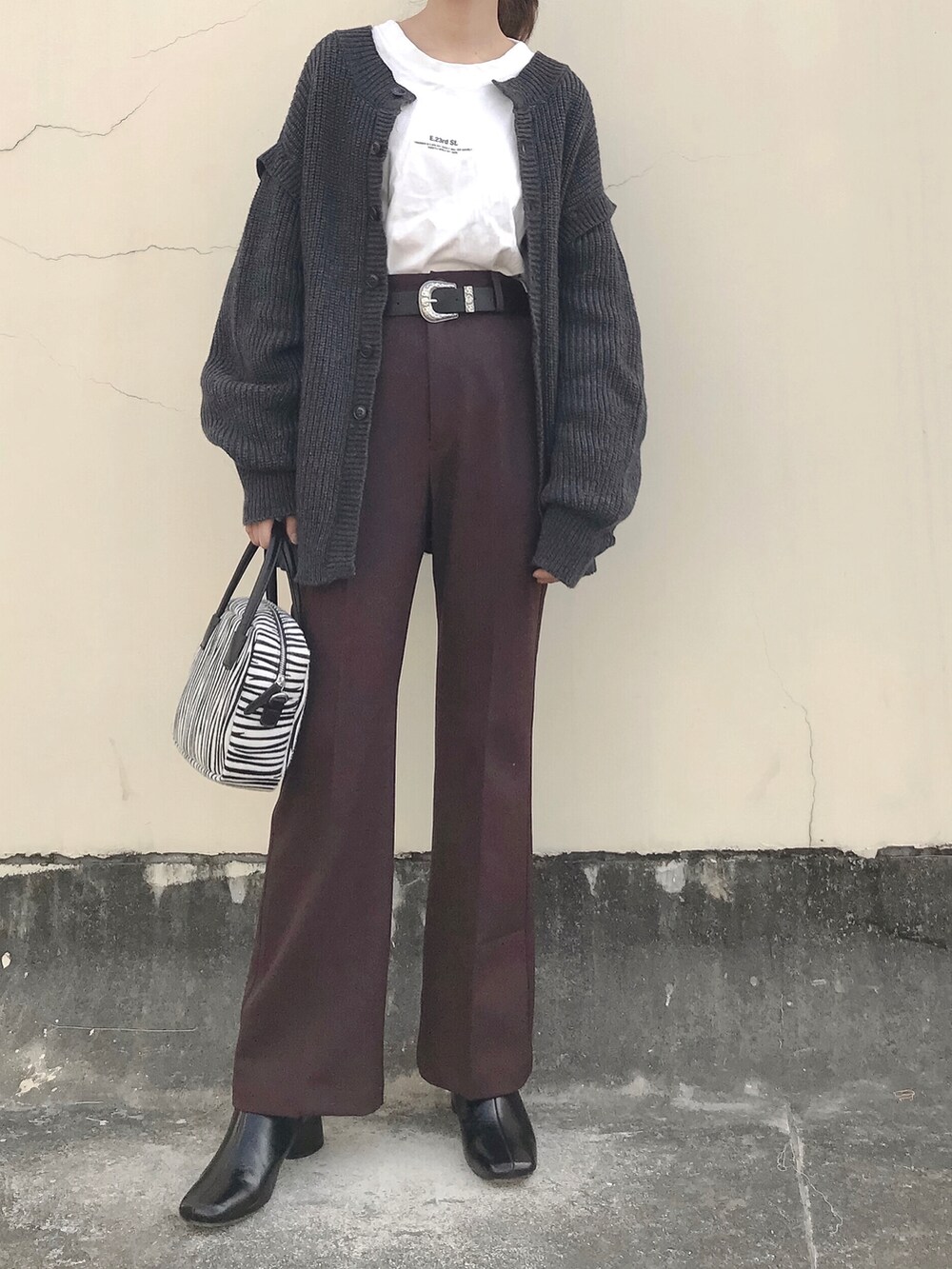 グレー系のニット/セーター、ホワイト系のTシャツ/カットソー、ブラウン系のその他パンツを着用したレディースの春コーディネートの2枚目の写真