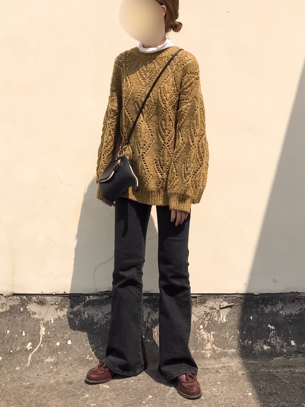 ブラウン系のニット/セーター、ブラック系のデニムパンツ、ブラウン系のローファーを着用したレディースの春コーディネートの4枚目の写真