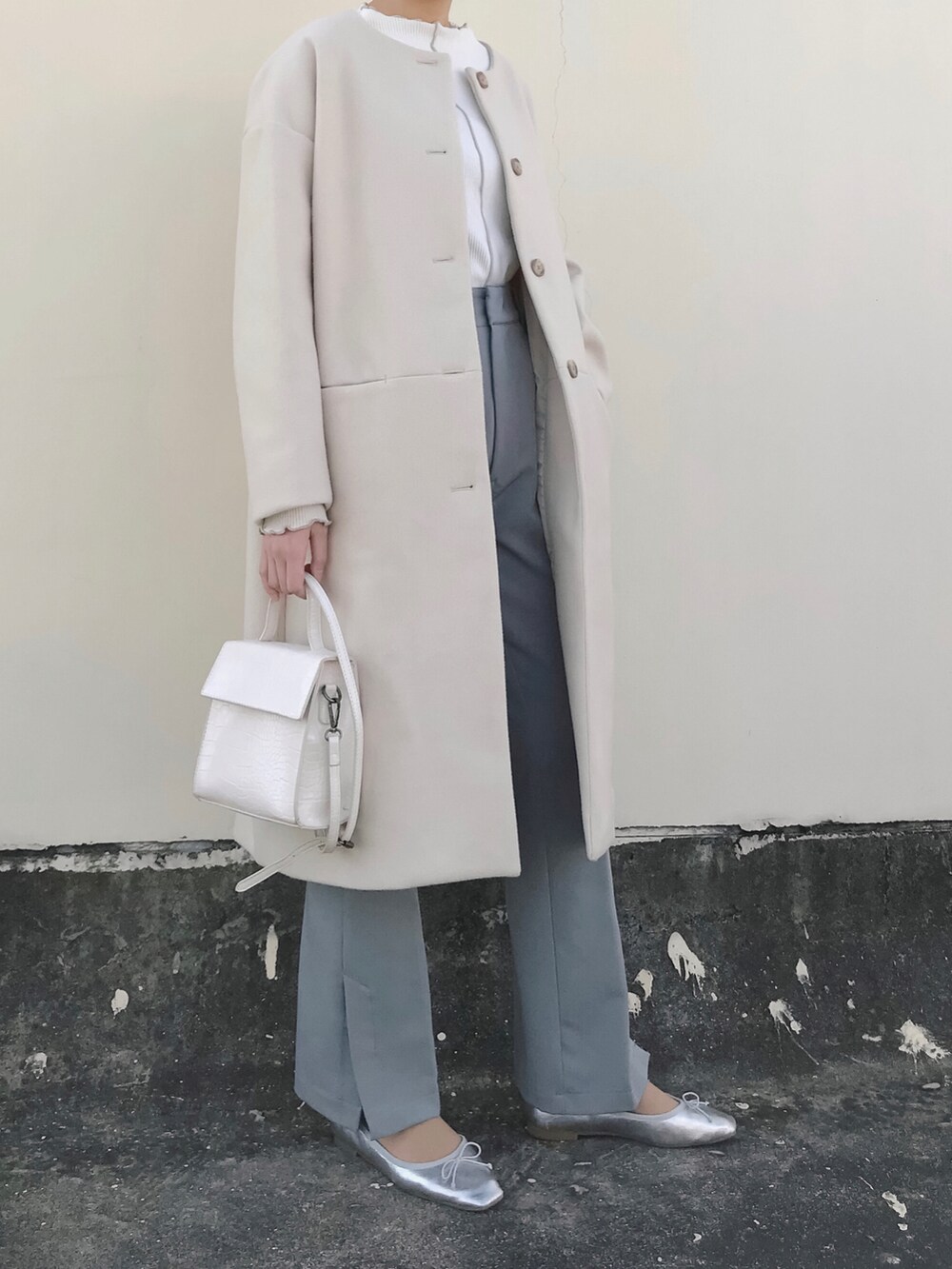ベージュ系のノーカラーコート、ホワイト系のTシャツ/カットソー、ホワイト系のショルダーバッグを着用したレディースの冬コーディネートの3枚目の写真