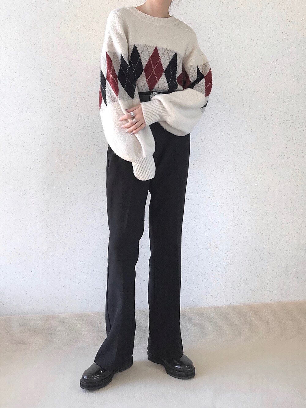 ホワイト系のニット/セーター、ブラック系のスラックス、ブラウン系のドレスシューズを着用したレディースの秋コーディネートの3枚目の写真