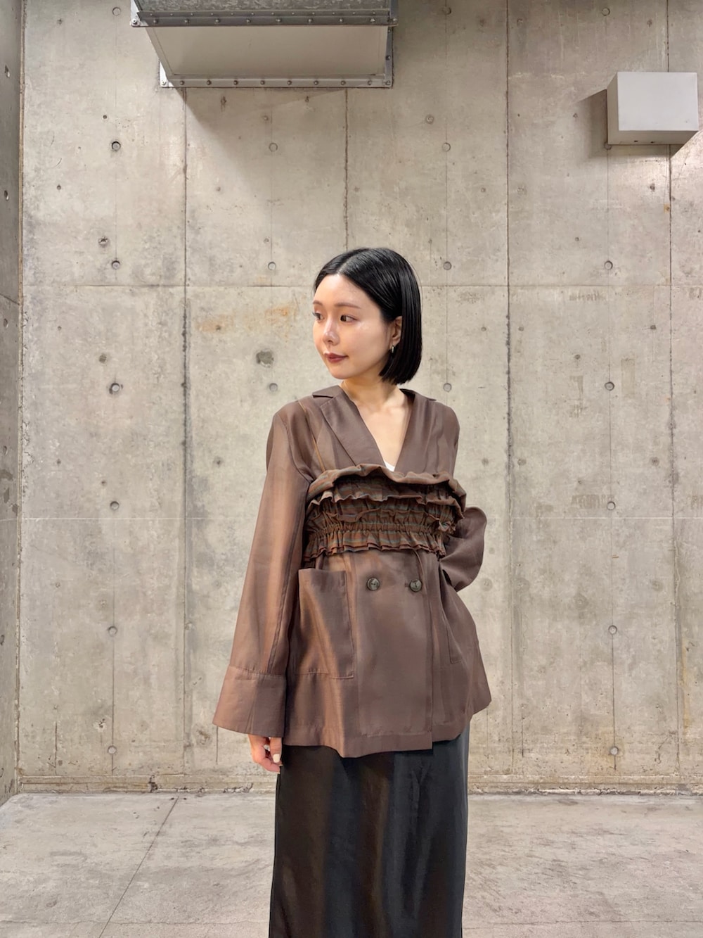 ブラウン系のテーラードジャケット、ブラウン系のTシャツ/カットソー、ブラック系のスカートを着用したレディースの春コーディネートの2枚目の写真