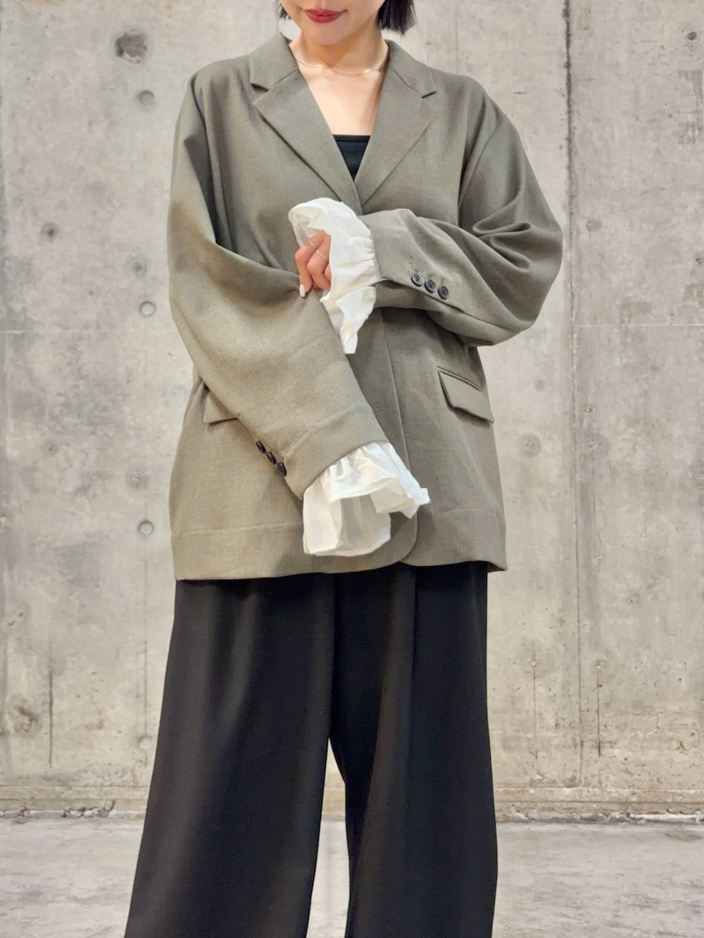 グレー系のその他アウター、ブラック系のスラックス、ブラック系のキャミソールを着用したレディースの冬コーディネートの2枚目の写真