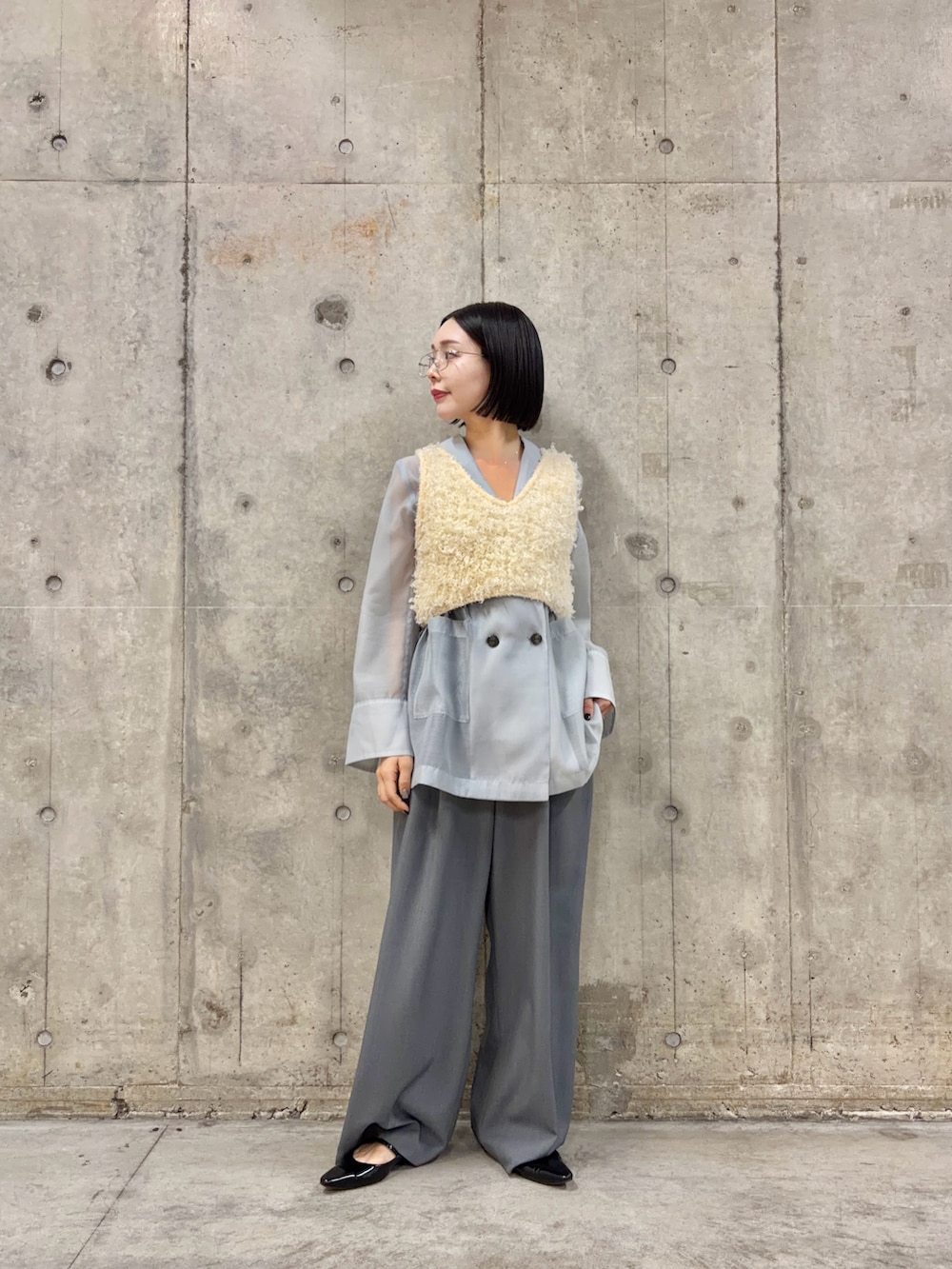 ブルー系のテーラードジャケット、グレー系のスラックス、ブラック系のパンプスを着用したレディースの春コーディネートの3枚目の写真