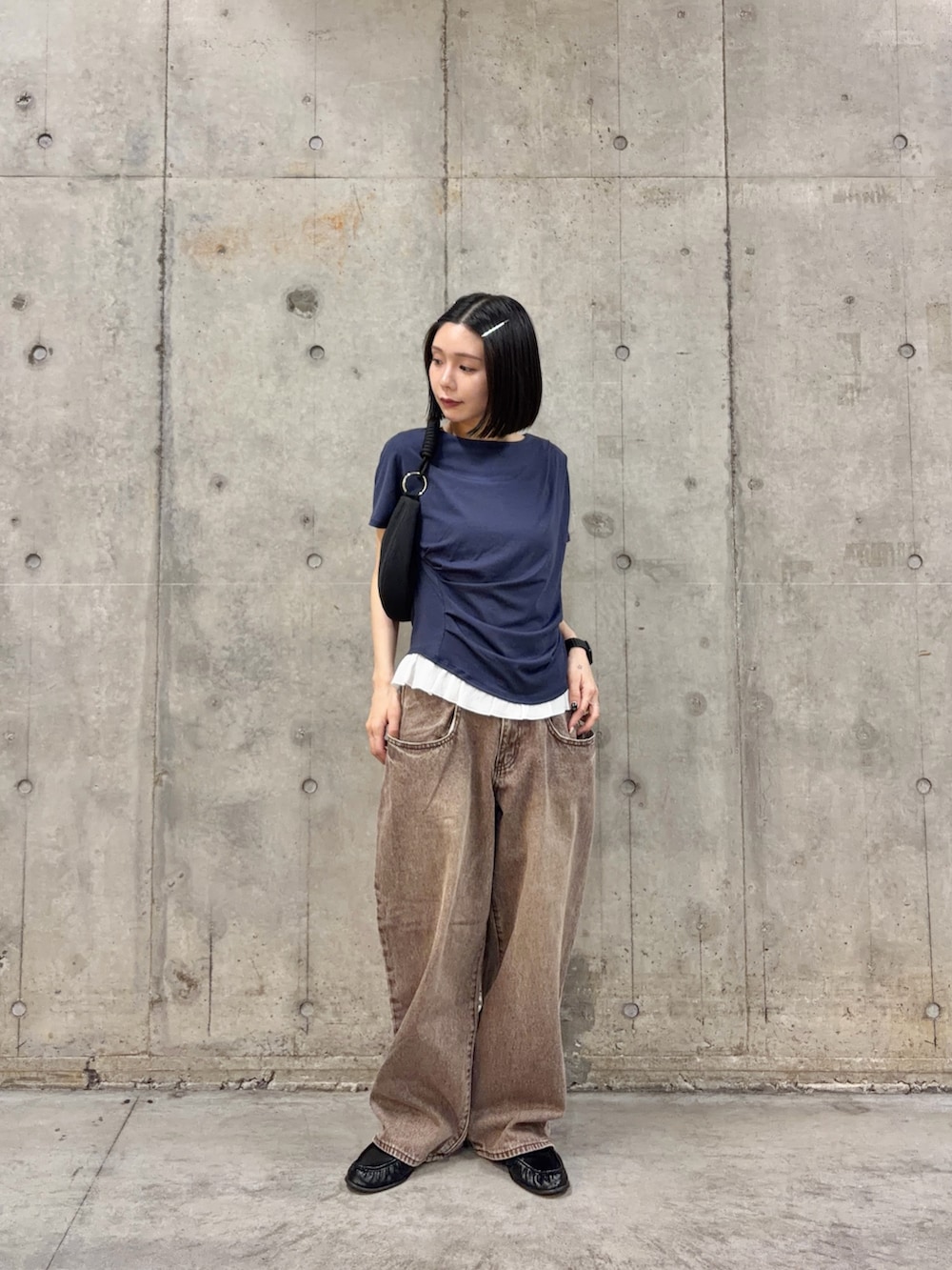 ブルー系のTシャツ/カットソー、ブラウン系のデニムパンツ、ブラック系のバッグを着用したレディースの春コーディネートの3枚目の写真