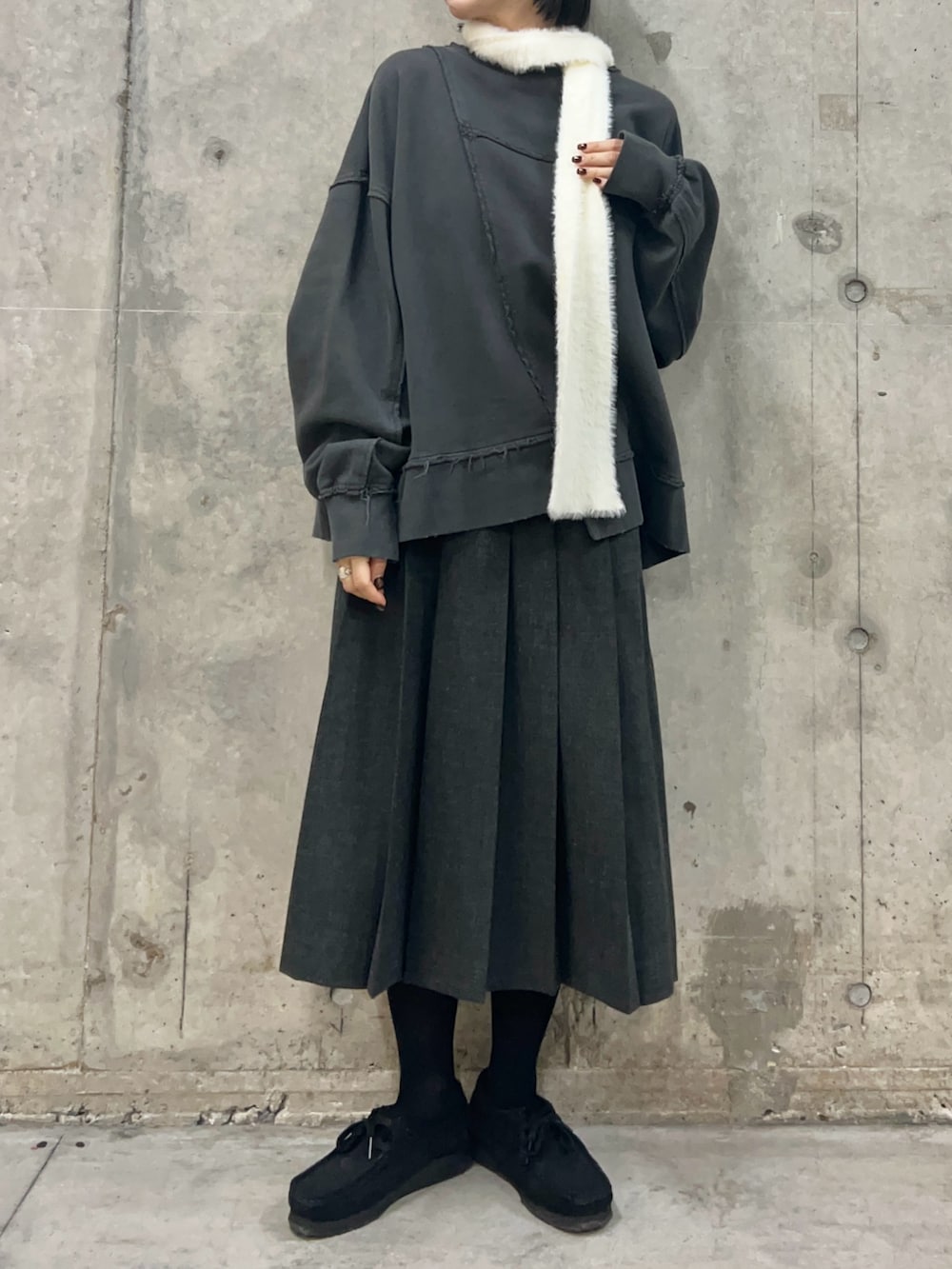 グレー系のスウェット、グレー系のスカート、ホワイト系のマフラーを着用したレディースの秋コーディネートの2枚目の写真