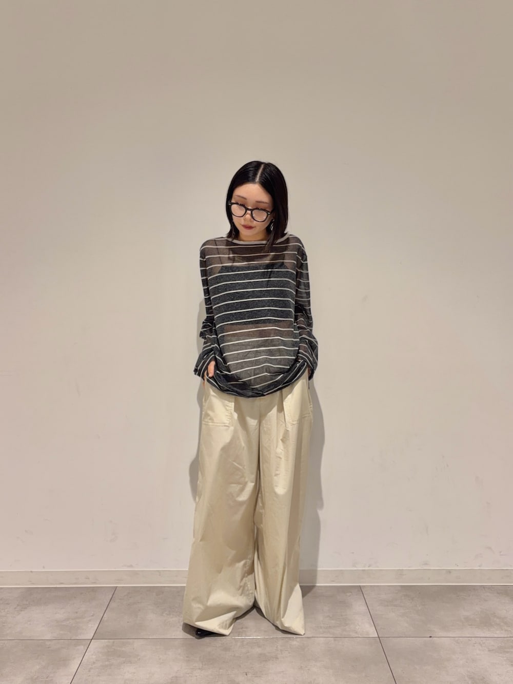 グレー系のニット/セーター、ベージュ系のその他パンツ、ブラック系のパンプスを着用したレディースの夏コーディネートの2枚目の写真