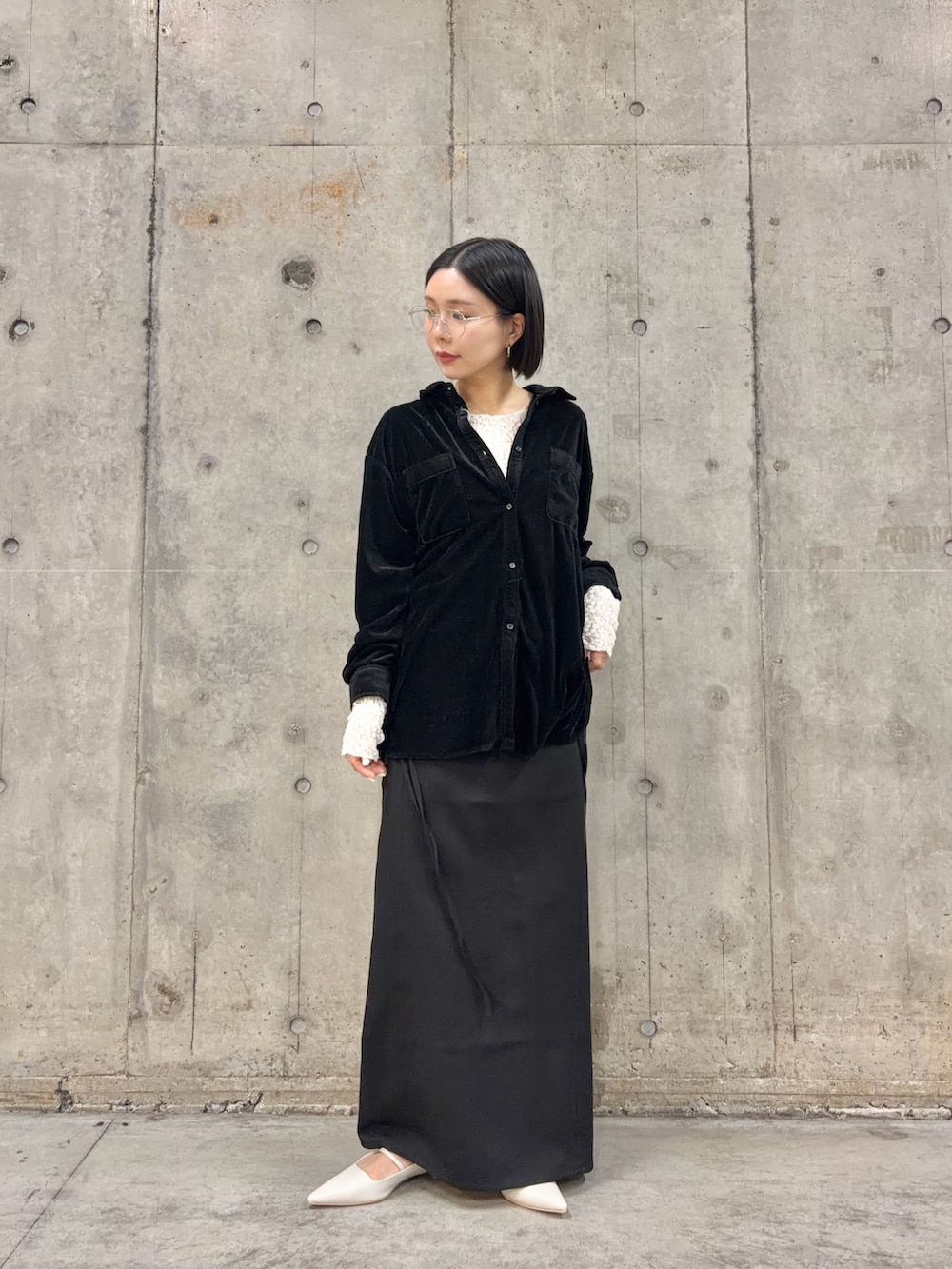 ブラック系のシャツ/ブラウス、ブラック系のスカート、ホワイト系のパンプスを着用したレディースの冬コーディネートの3枚目の写真