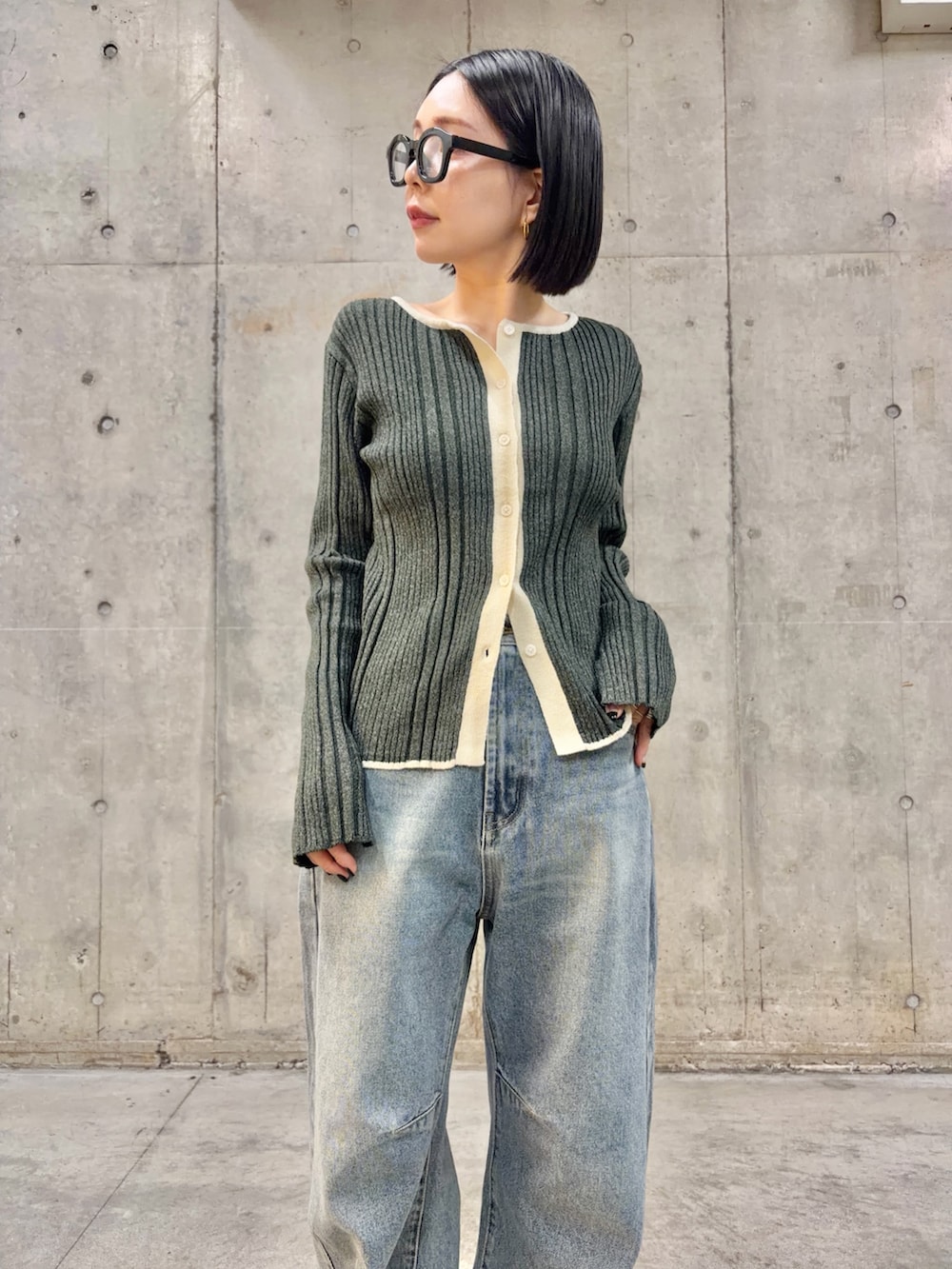 グレー系のニット/セーター、ブルー系のデニムパンツ、ブラック系のメガネを着用したレディースの冬コーディネートの3枚目の写真