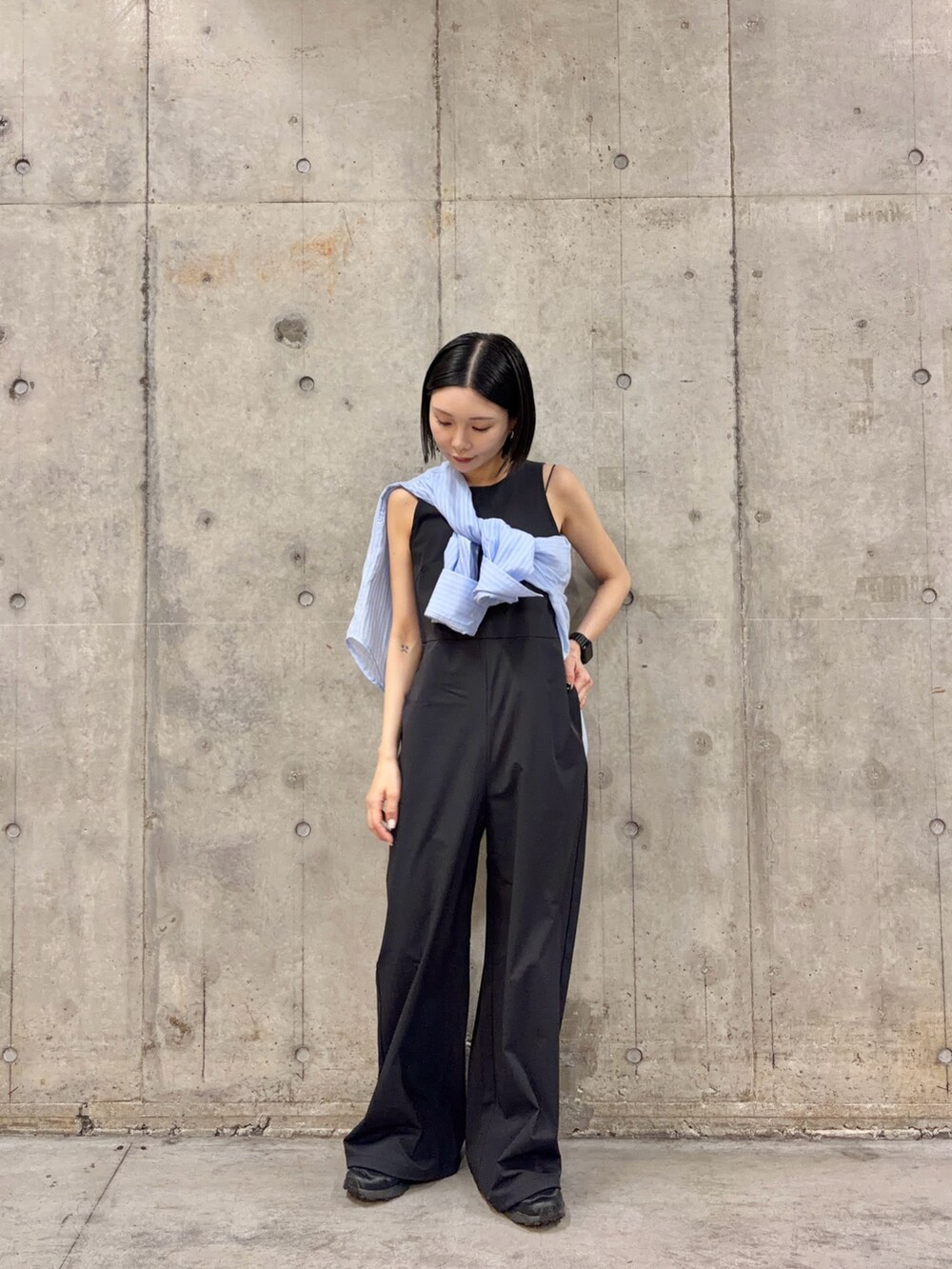 ブルー系のシャツ/ブラウス、ブラック系のサロペット/オーバーオールを着用したレディースの春コーディネートの2枚目の写真