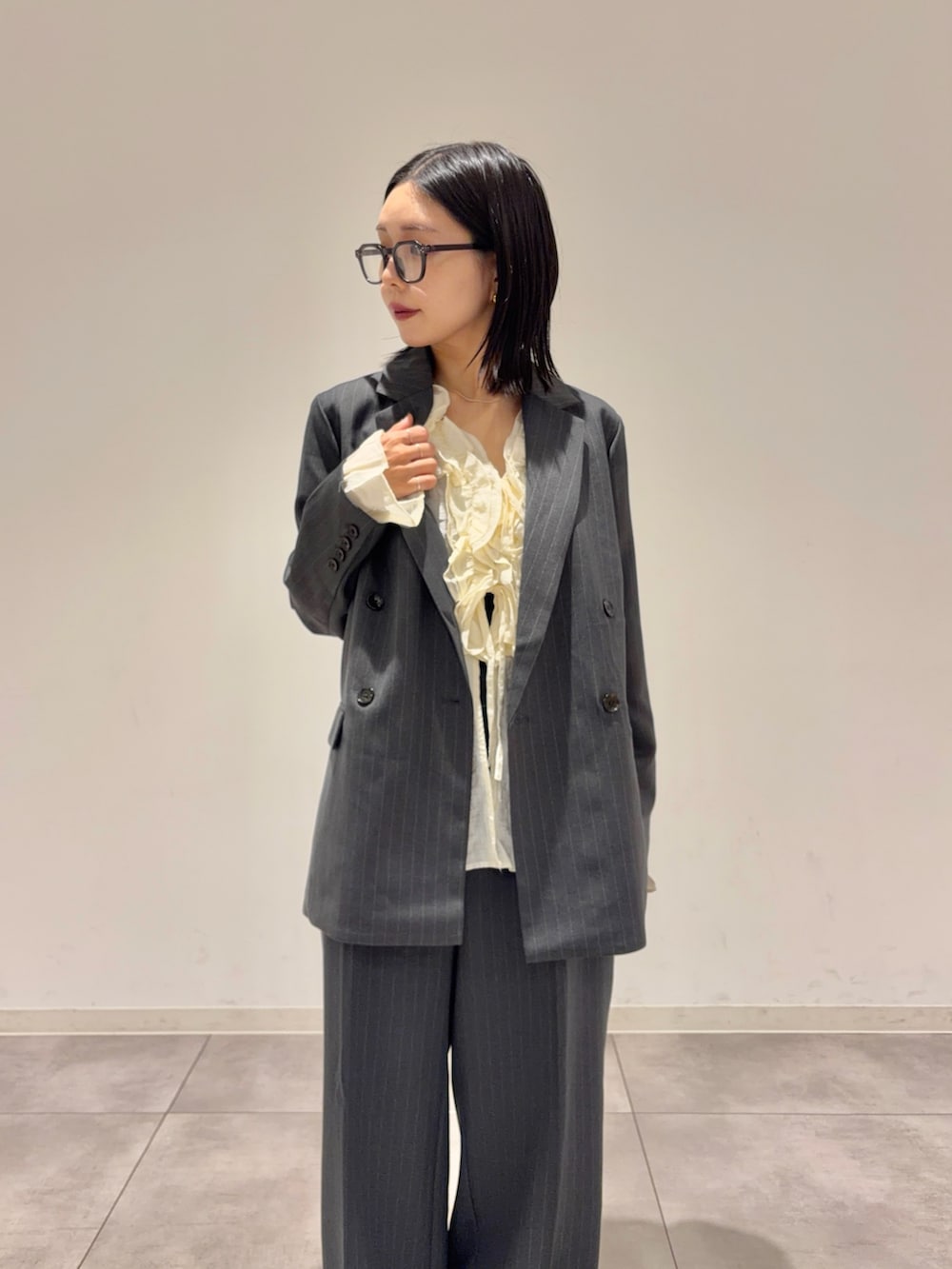 グレー系のその他アウター、ホワイト系のシャツ/ブラウス、グレー系のスラックスを着用したレディースの秋コーディネートの2枚目の写真