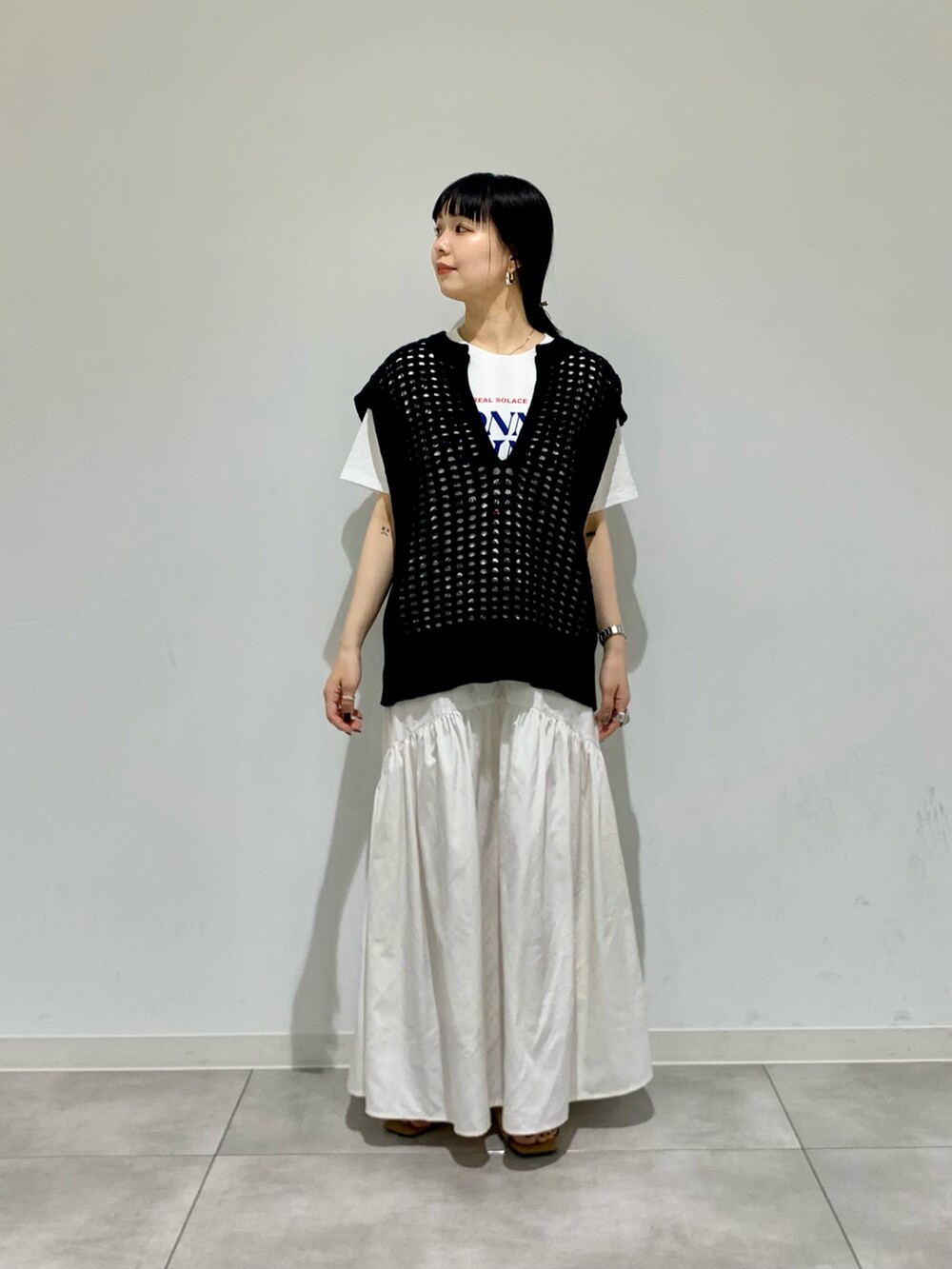 ホワイト系のサンダル、その他のTシャツ/カットソー、ブラック系のベストを着用したレディースの春コーディネートの2枚目の写真