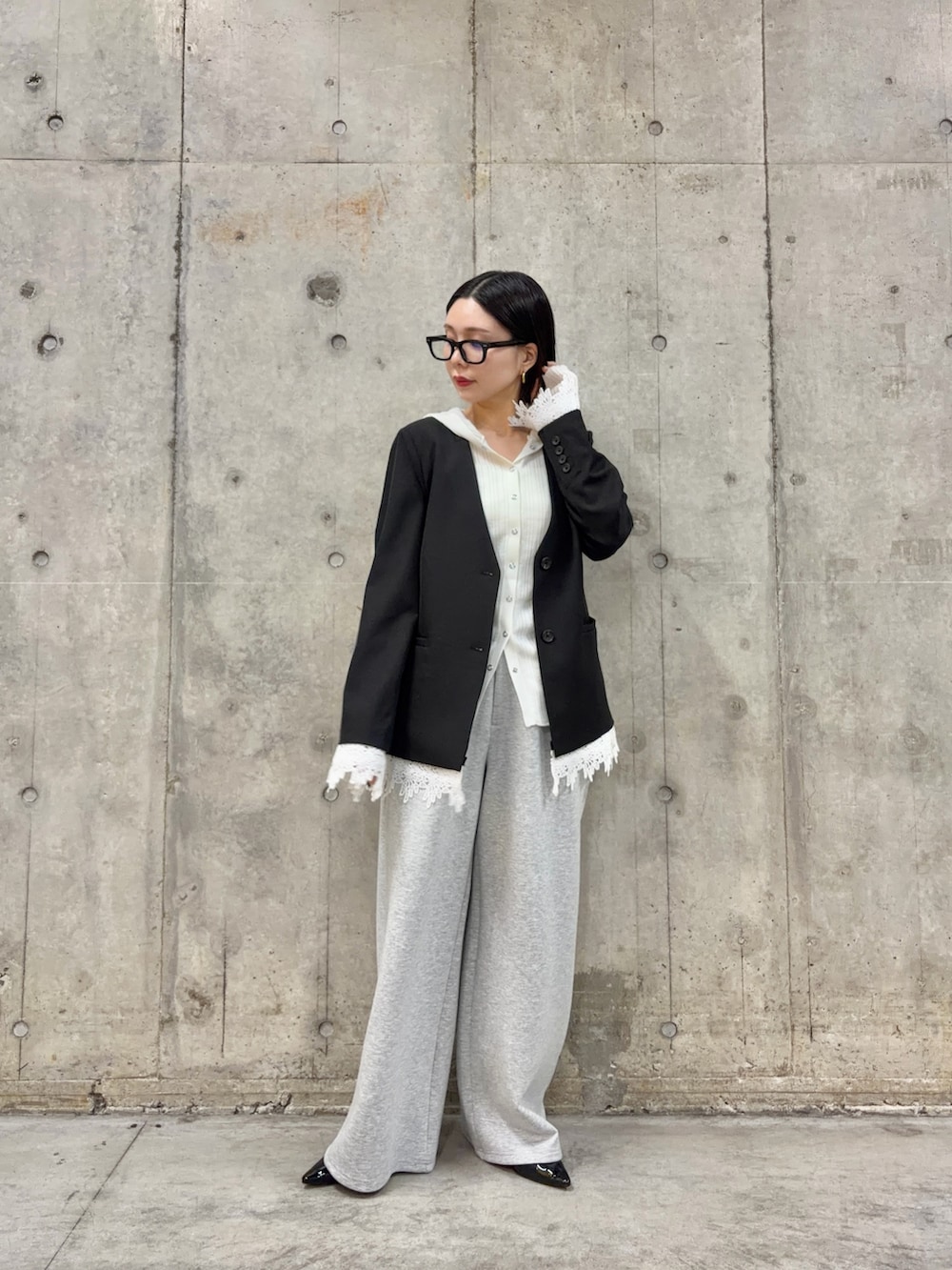 ブラック系のパンプス、グレー系のその他パンツ、ブラック系のノーカラージャケットを着用したレディースの春コーディネートの3枚目の写真