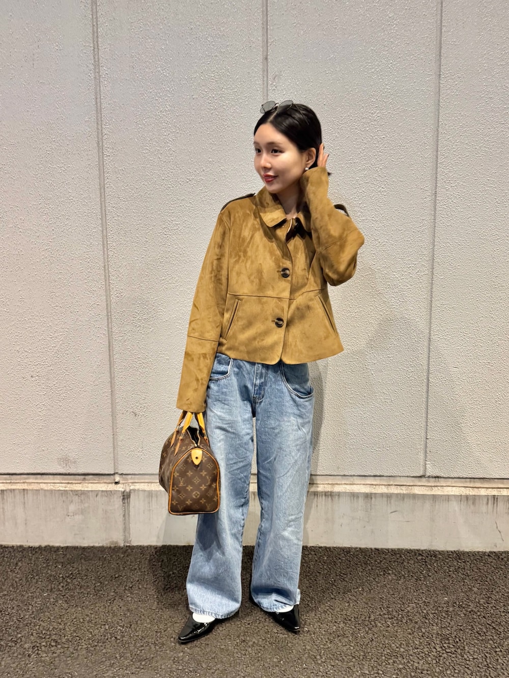 ブルー系のデニムパンツ、ブラック系のパンプス、シルバー系のピアス（両耳用）を着用したレディースの春コーディネートの3枚目の写真