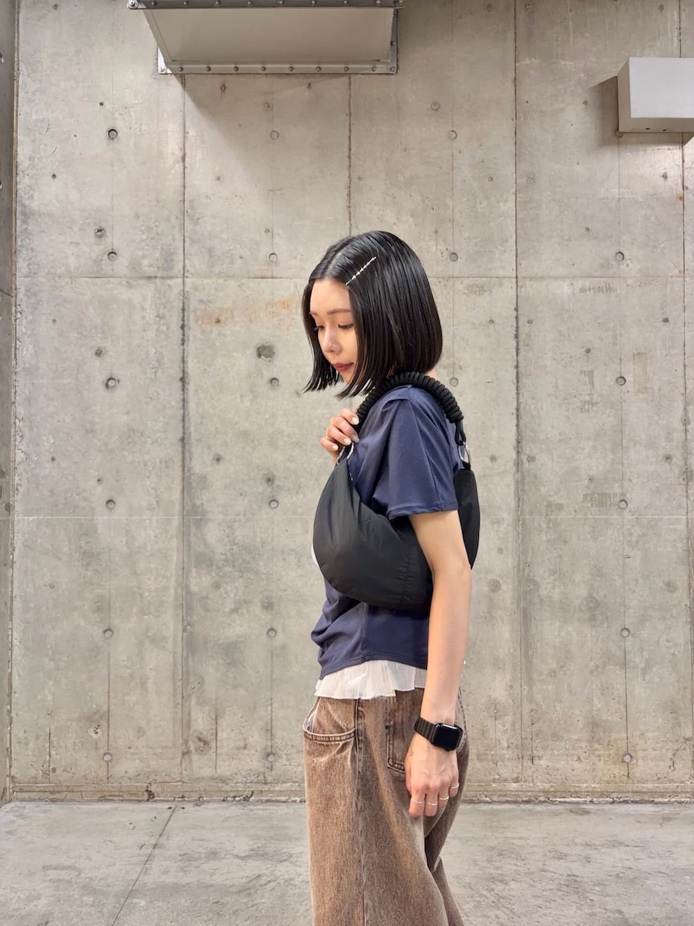 ブルー系のTシャツ/カットソー、ブラウン系のデニムパンツ、ブラック系のバッグを着用したレディースの春コーディネートの2枚目の写真