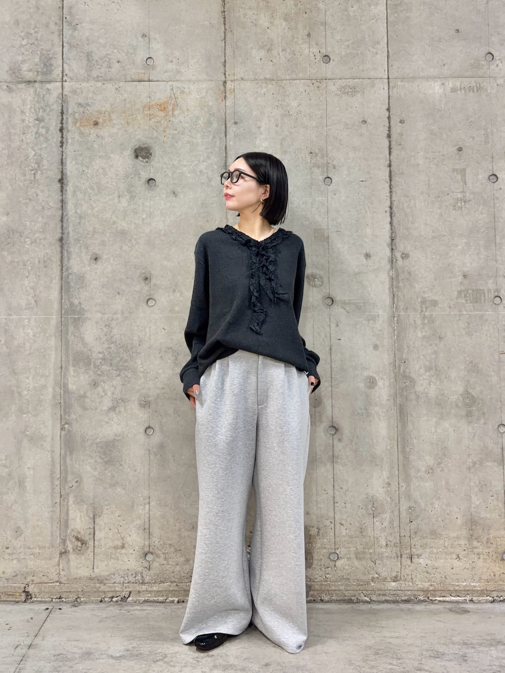 グレー系のスラックス、グレー系のTシャツ/カットソー、ブラック系のローファーを着用したレディースの春コーディネートの4枚目の写真