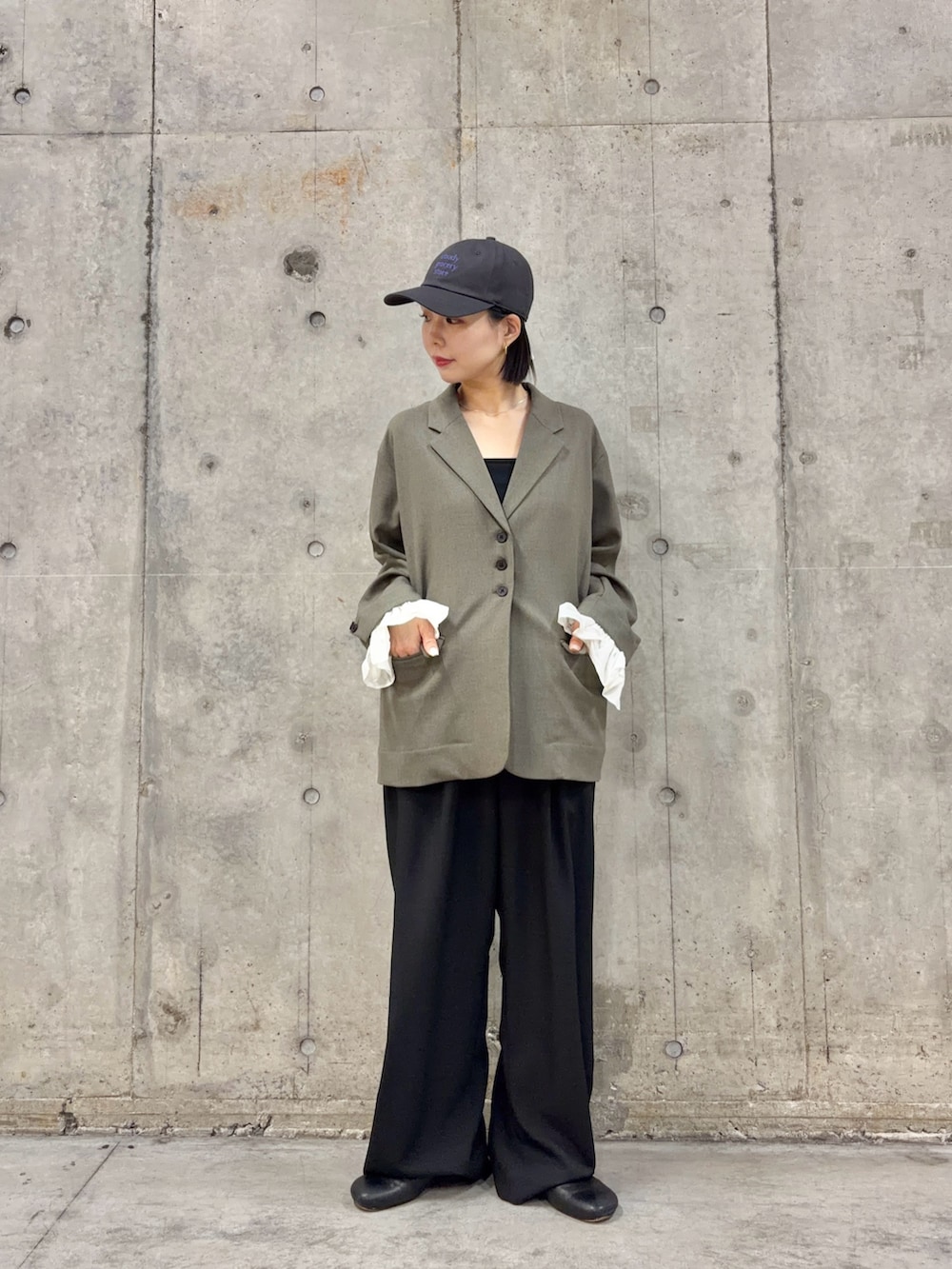 グレー系のその他アウター、ブラック系のスラックス、ブラック系のキャミソールを着用したレディースの冬コーディネートの3枚目の写真