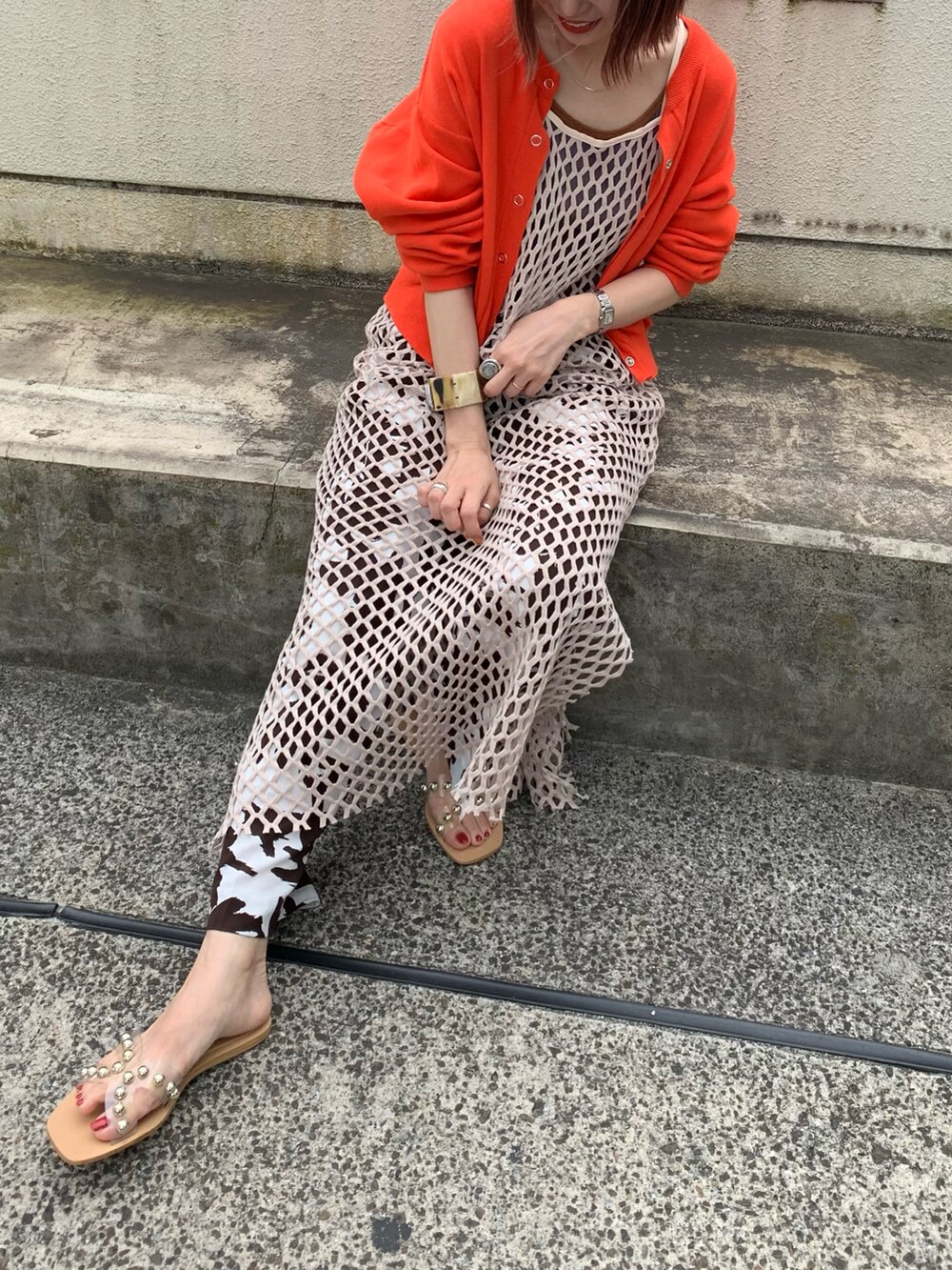 オレンジ系のカーディガン/ボレロ、ブルー系のタンクトップ、ブラウン系のその他パンツを着用したレディースの夏コーディネートの2枚目の写真