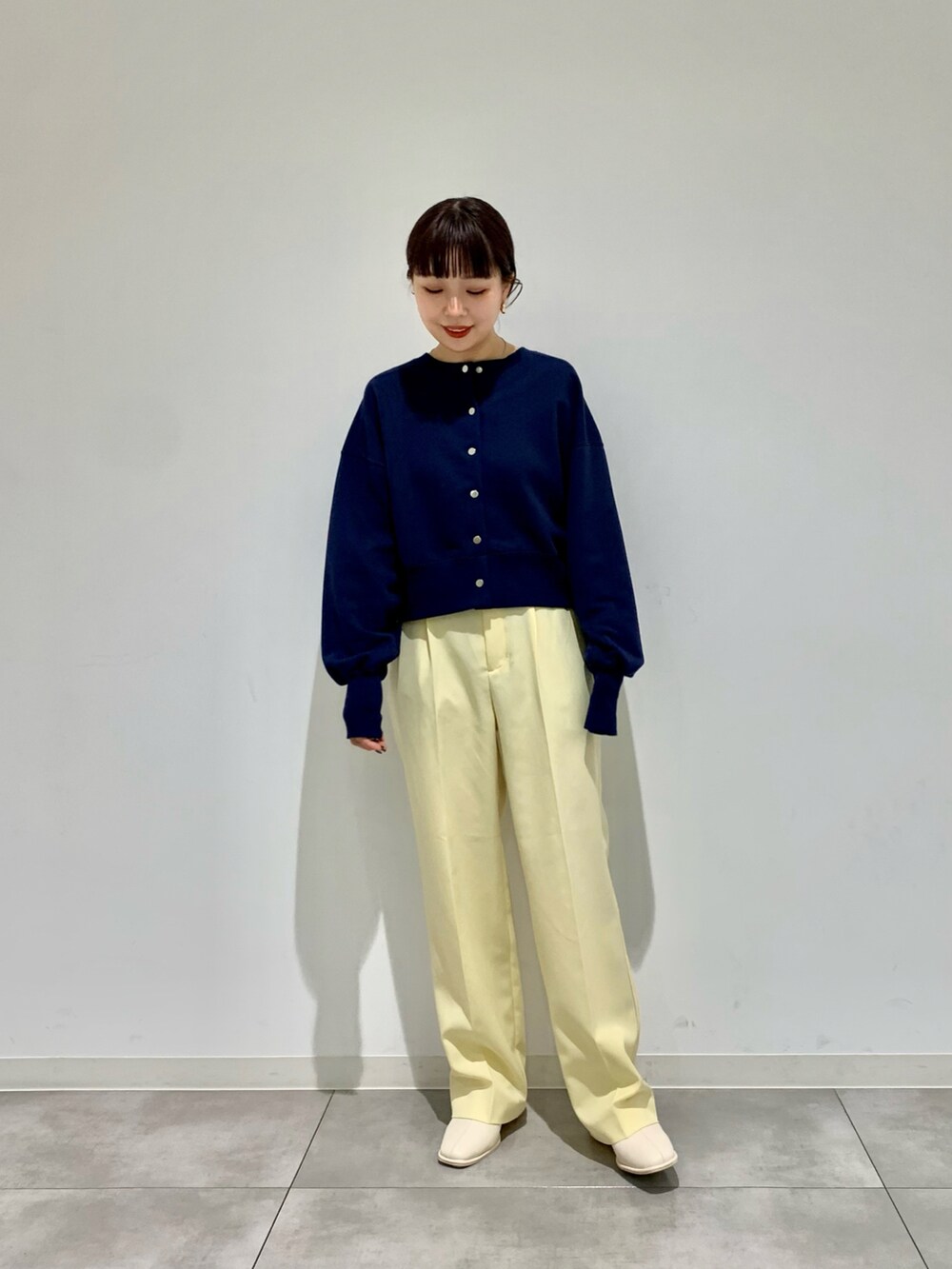 イエロー系のその他パンツ、ブルー系のカーディガン/ボレロ、ブラック系のブーツを着用したレディースの冬コーディネートの2枚目の写真