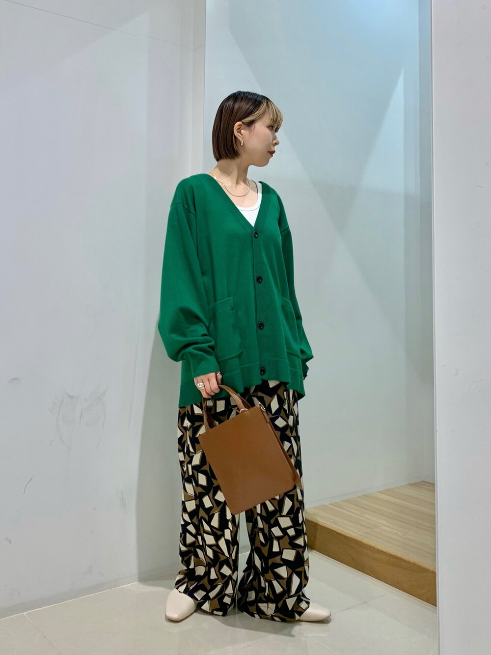 ブルー系のカーディガン/ボレロ、ブラウン系のその他パンツ、グリーン系のトートバッグを着用したレディースの冬コーディネートの2枚目の写真