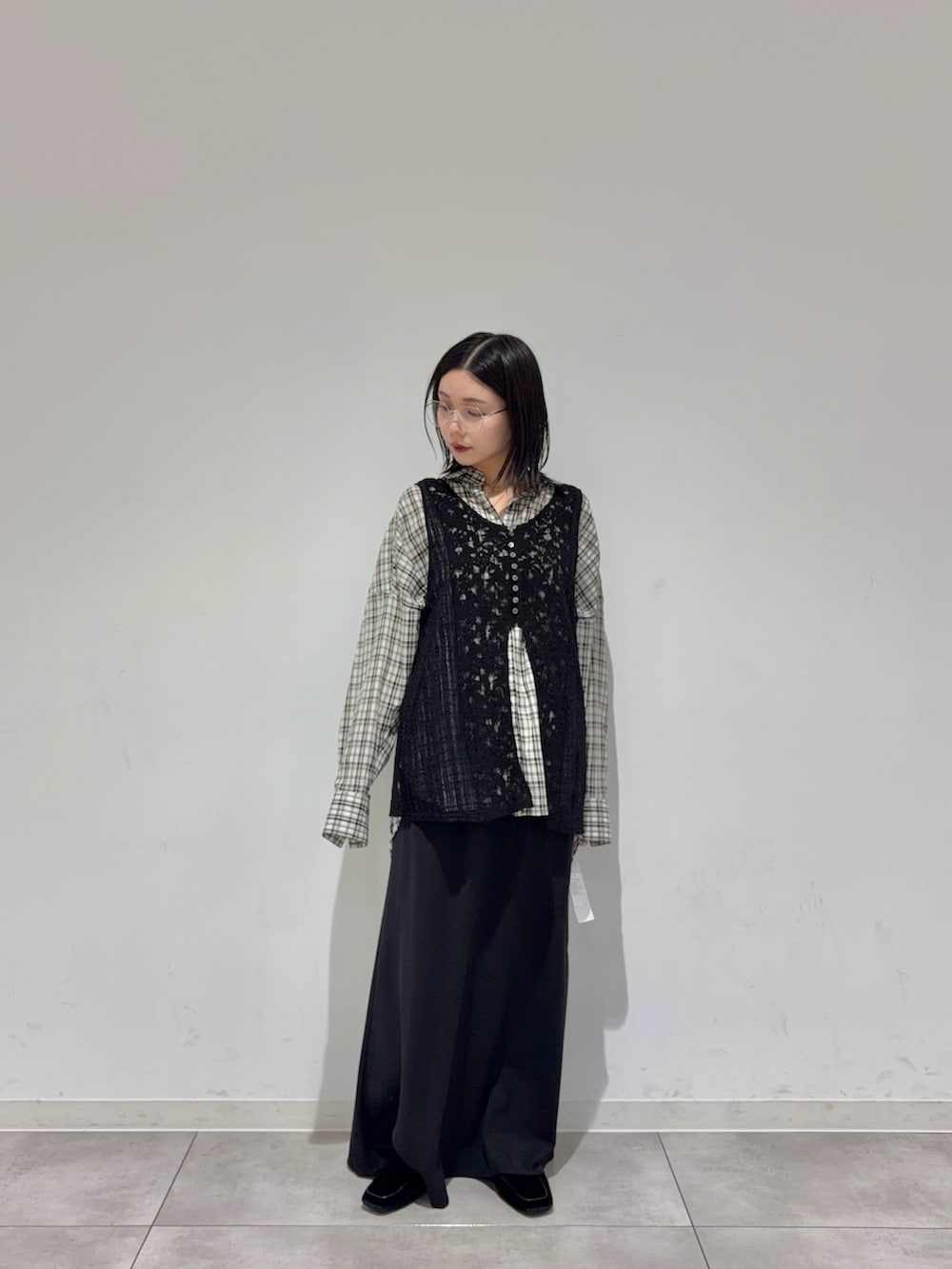 ブラック系のカーディガン/ボレロ、ホワイト系のシャツ/ブラウス、ブラック系のスカートを着用したレディースの秋コーディネートの2枚目の写真