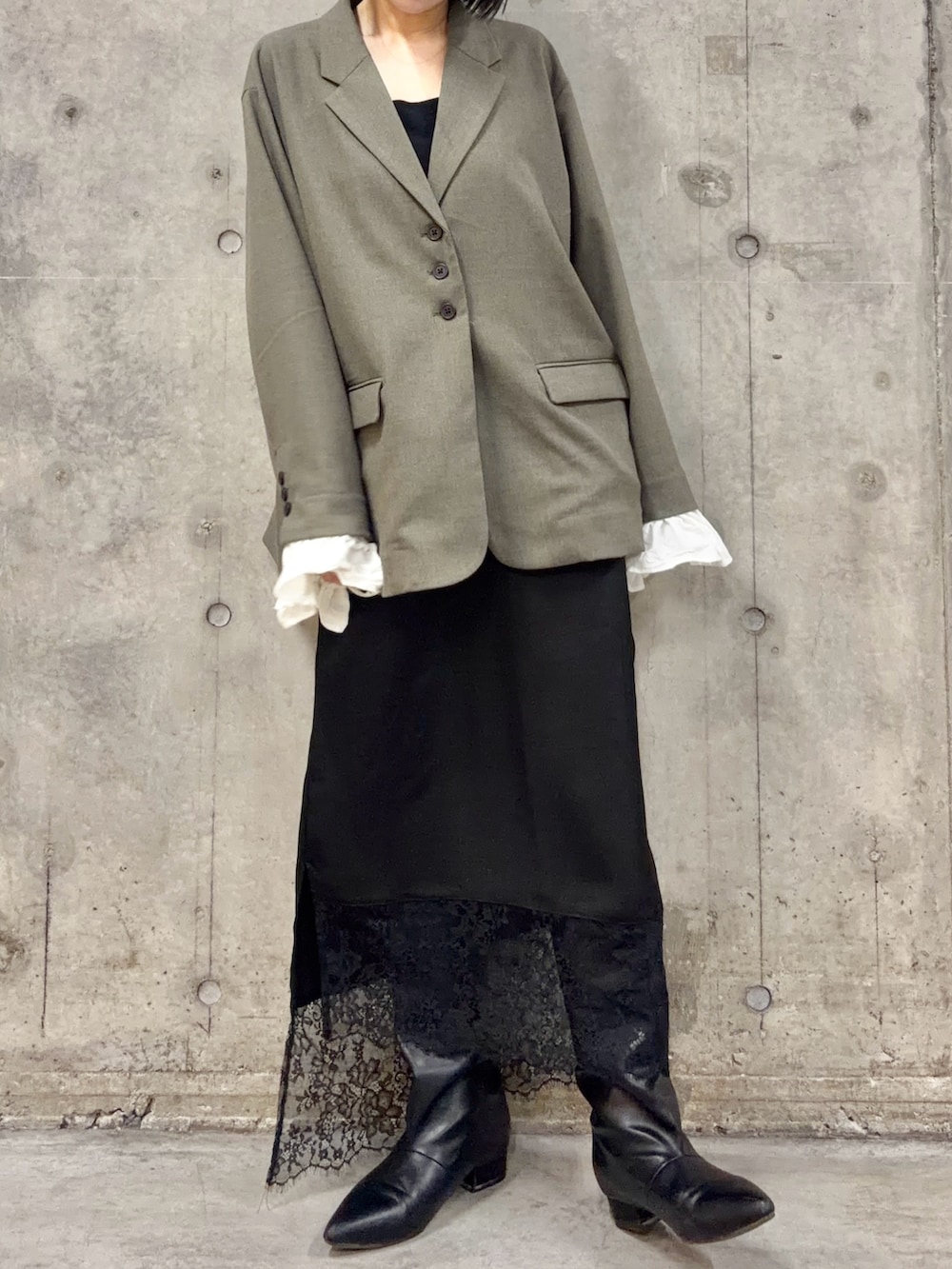 グレー系のその他アウター、ブラック系のスカート、ブラック系のブーツを着用したレディースの春コーディネートの2枚目の写真
