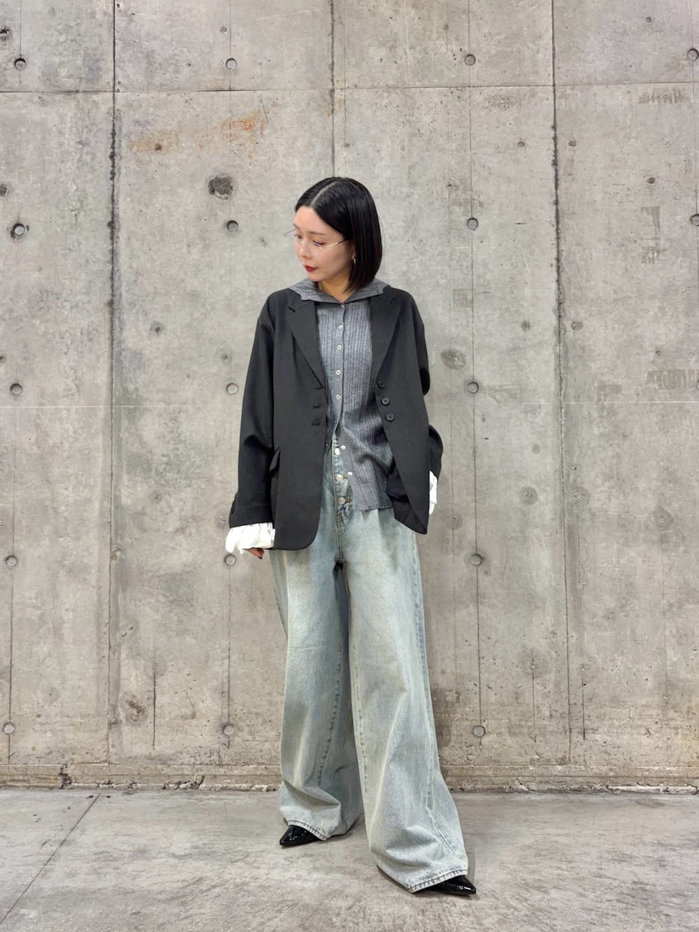 グレー系のニット/セーター、グレー系のその他アウター、ブルー系のデニムパンツを着用したレディースの春コーディネートの2枚目の写真