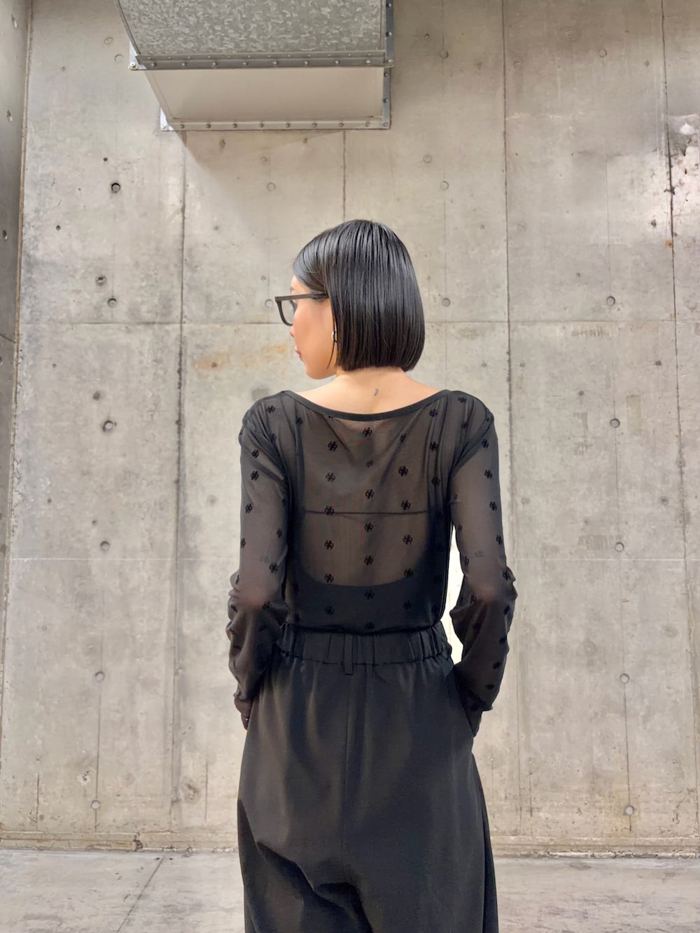 ブラック系のTシャツ/カットソー、ブラック系のスニーカー、ブラック系のメガネを着用したレディースの春コーディネートの4枚目の写真
