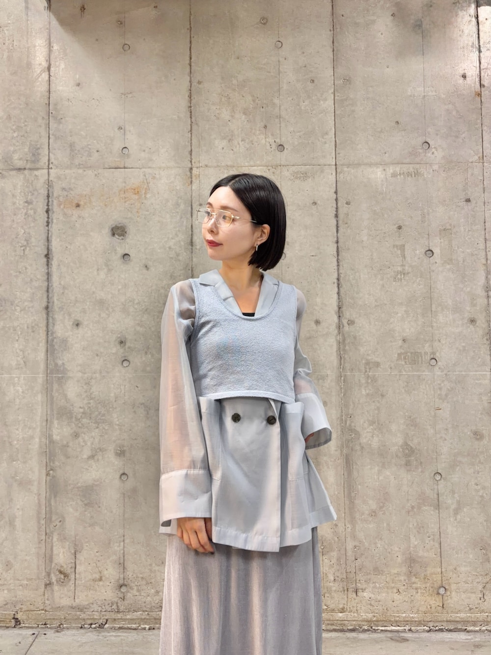 ブルー系のテーラードジャケット、ブルー系のニット/セーター、グレー系のスカートを着用したレディースの春コーディネートの3枚目の写真