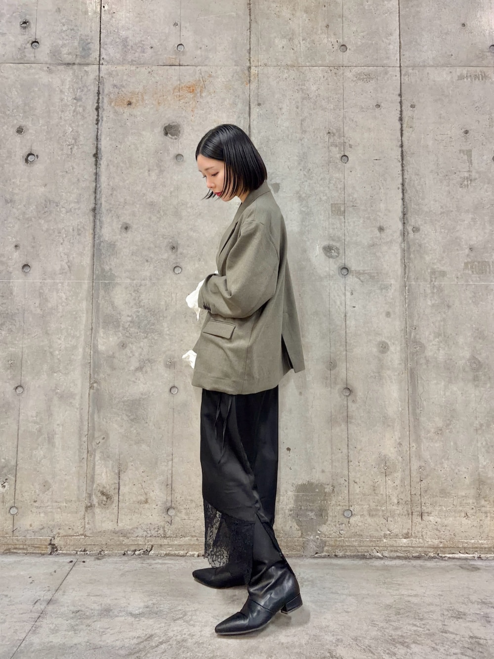 グレー系のその他アウター、ブラック系のスカート、ブラック系のブーツを着用したレディースの春コーディネートの3枚目の写真