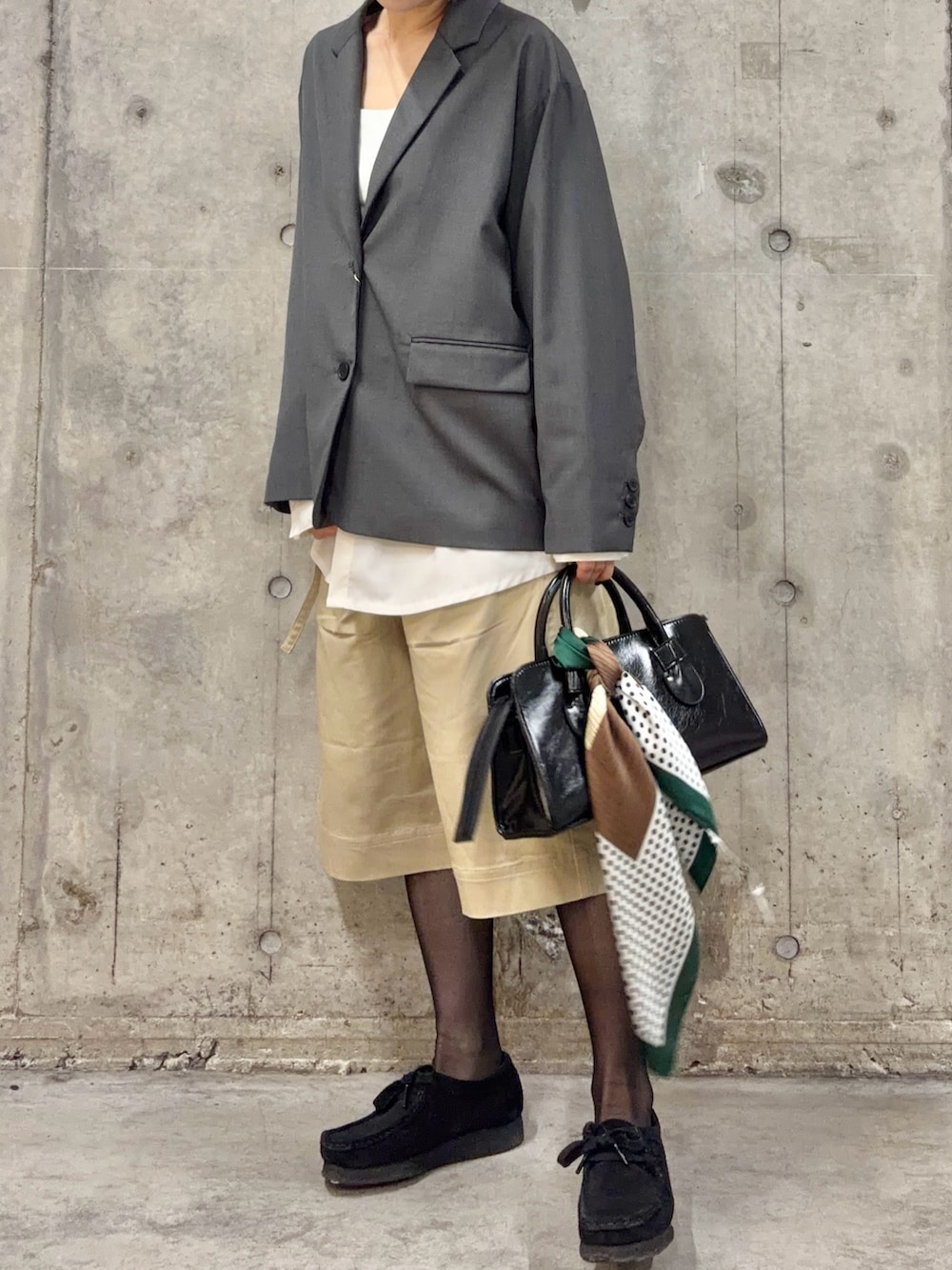 グレー系のその他アウター、ベージュ系のその他パンツ、ブラック系のボストンバッグを着用したレディースの春コーディネートの2枚目の写真