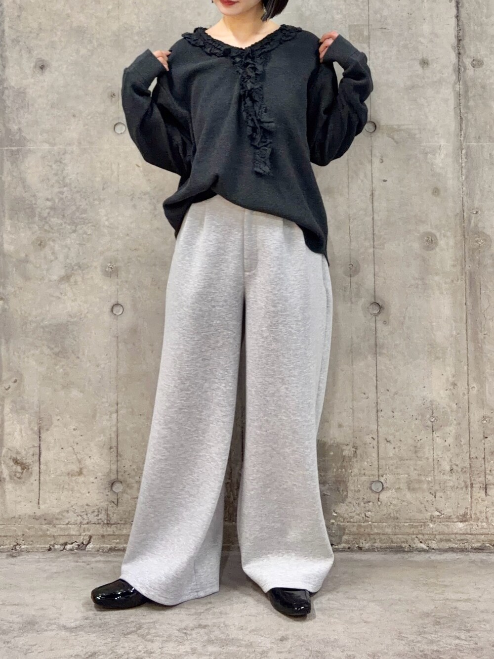 グレー系のスラックス、グレー系のTシャツ/カットソー、ブラック系のローファーを着用したレディースの春コーディネートの3枚目の写真