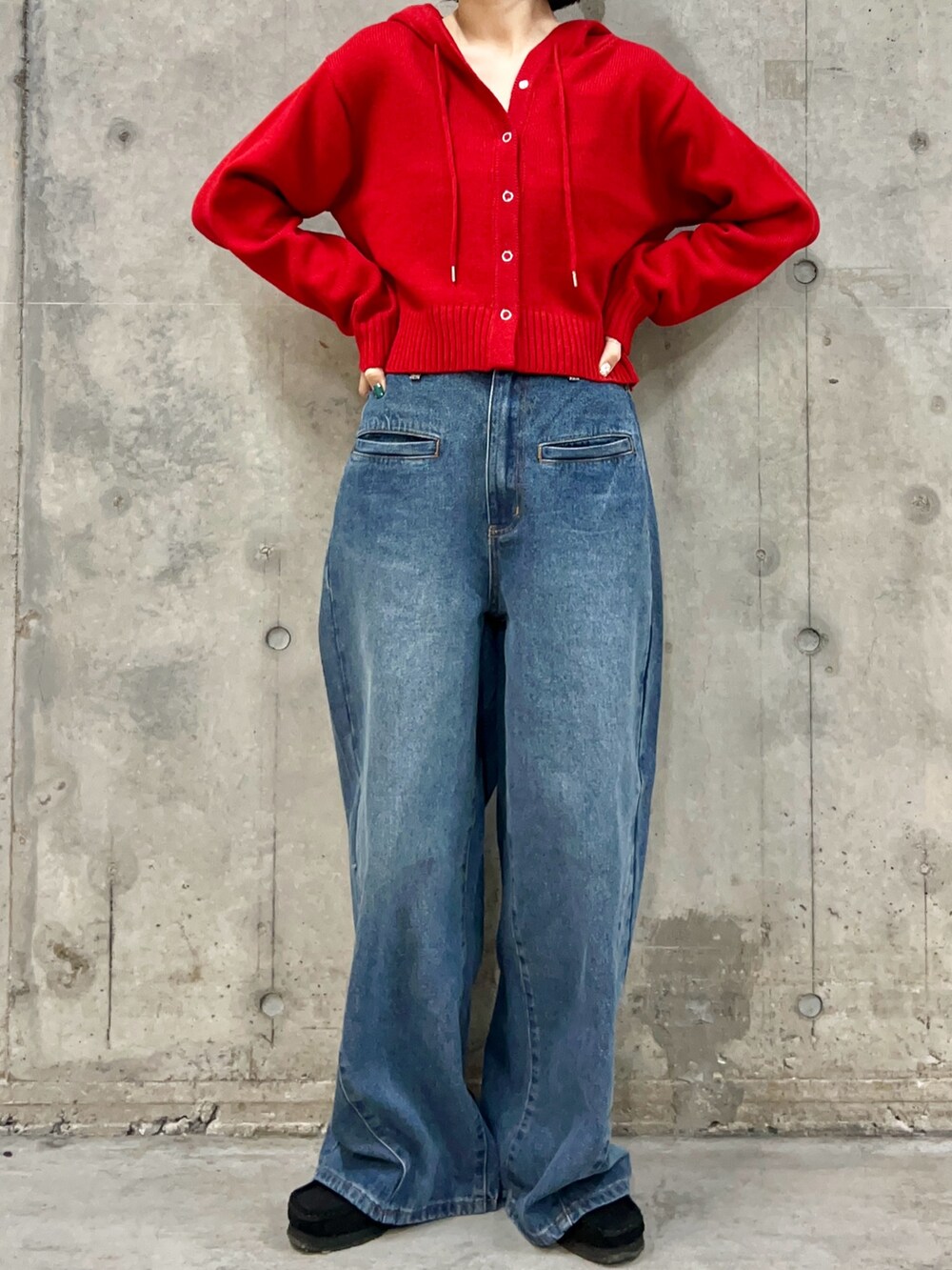 レッド系のニット/セーター、ブルー系のデニムパンツ、ブラック系のメガネを着用したレディースの秋コーディネートの3枚目の写真