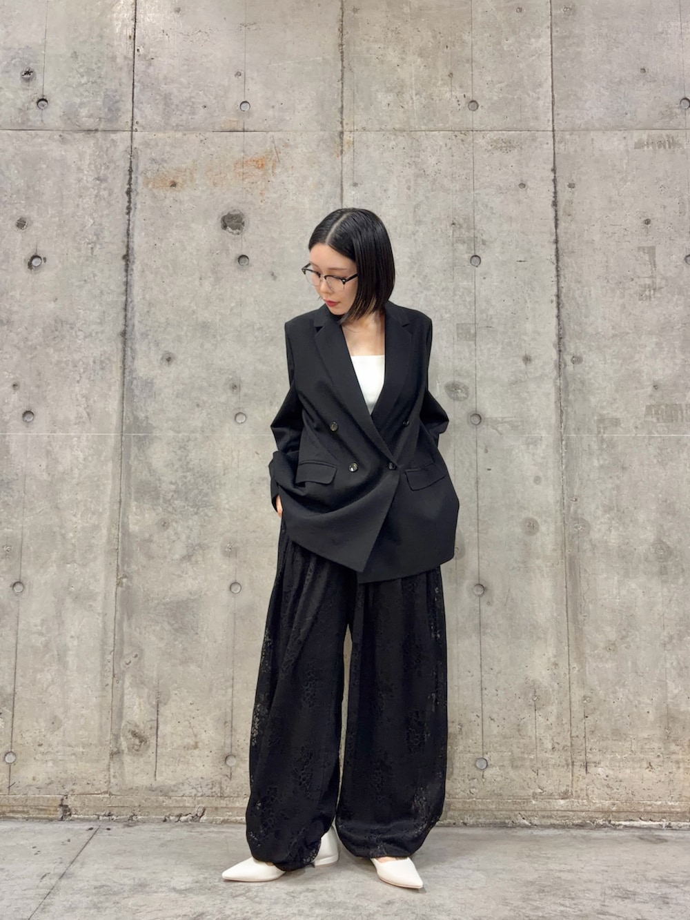 ホワイト系のキャミソール、ブラック系のテーラードジャケット、ブラック系のその他パンツを着用したレディースの冬コーディネートの3枚目の写真