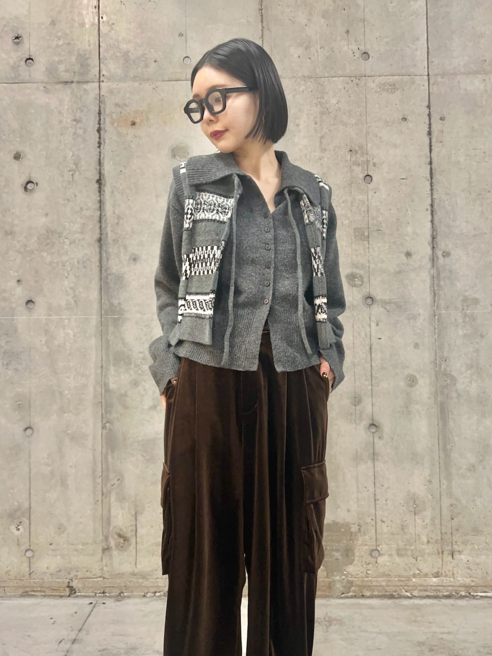 グレー系のニット/セーター、グレー系のベスト、ブラウン系のその他パンツを着用したレディースの秋コーディネートの2枚目の写真