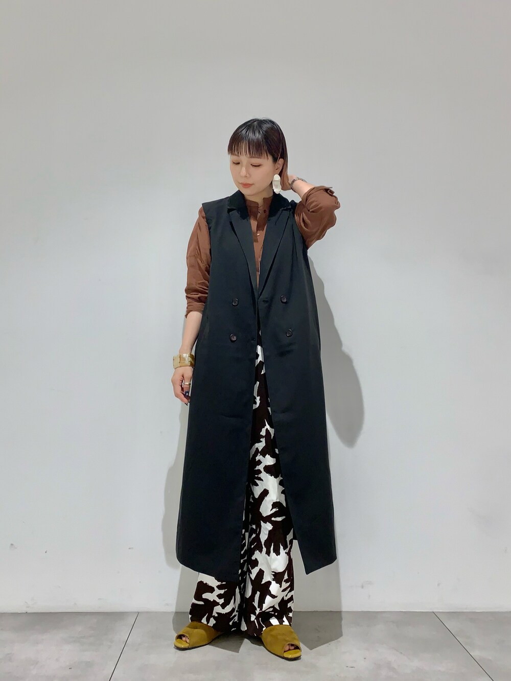 オレンジ系のシャツ/ブラウス、ブラック系のキャミソール、ブラック系のベストを着用したレディースの夏コーディネートの2枚目の写真