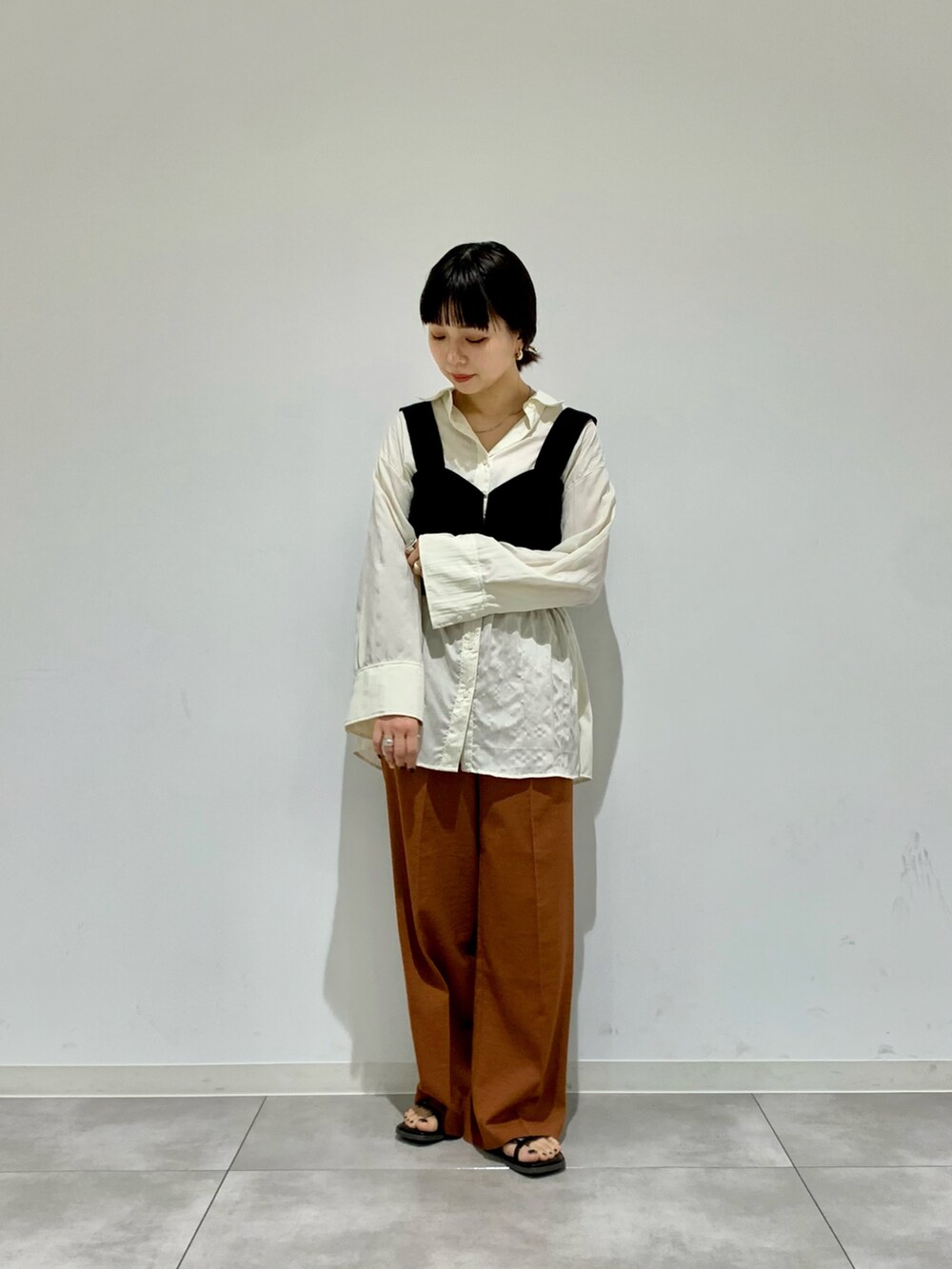 ピンク系のTシャツ/カットソー、ブラック系のニット/セーター、レッド系のスラックスを着用したレディースの春コーディネートの2枚目の写真