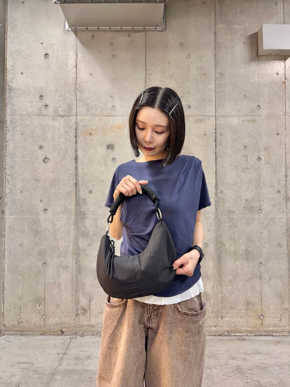 ブルー系のTシャツ/カットソー、ブラウン系のデニムパンツ、ブラック系のバッグを着用したレディースの春コーディネートの4枚目の写真