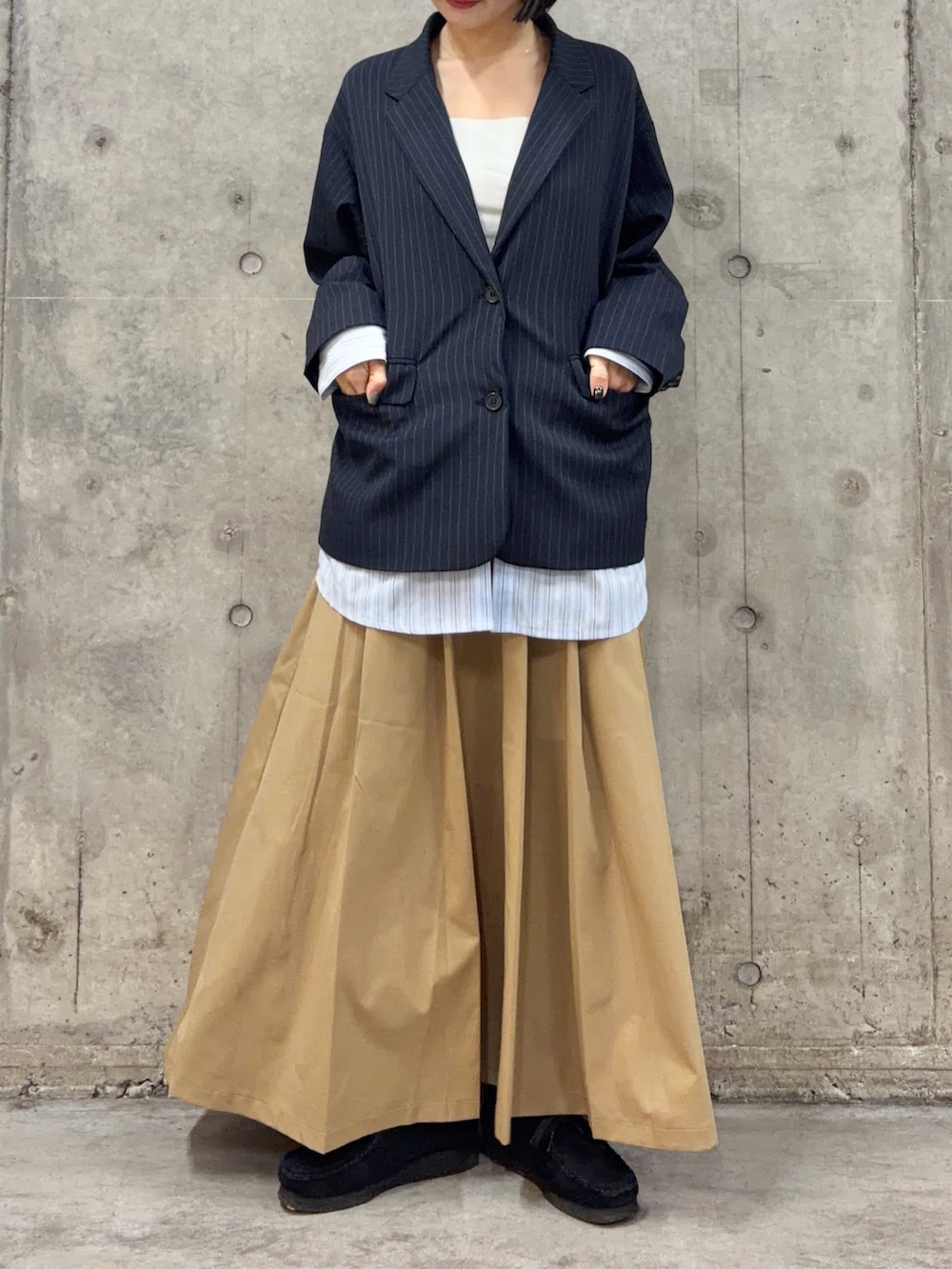 ブルー系のその他アウター、ベージュ系のスカート、ブラック系のブーツを着用したレディースの春コーディネートの3枚目の写真